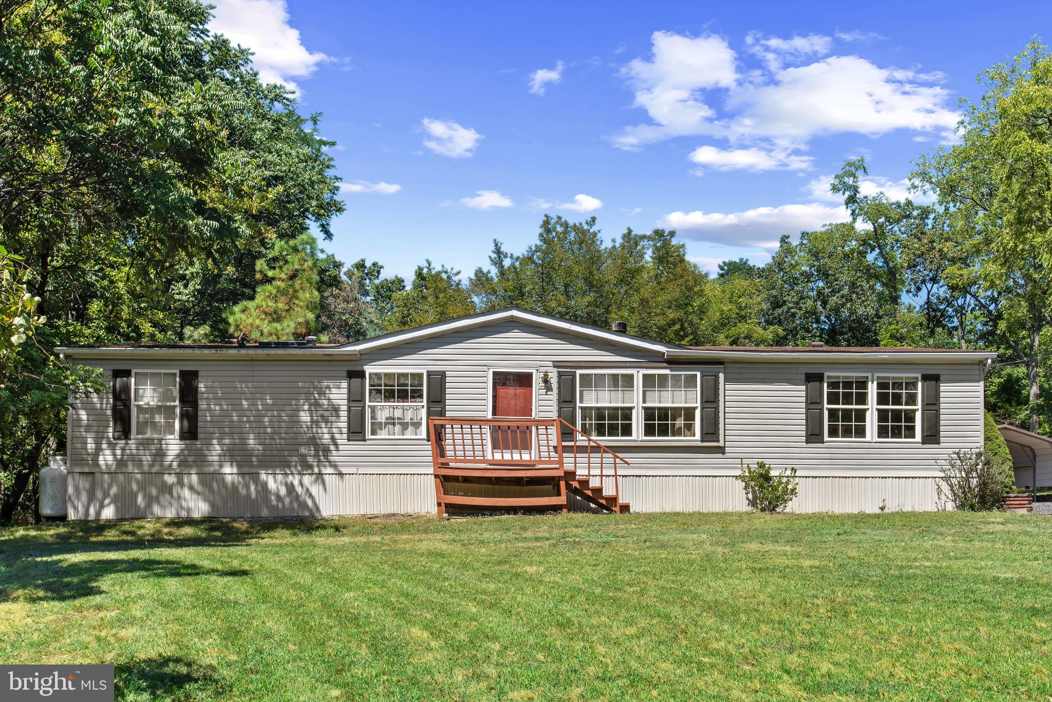 Secluded yet surprisingly close to local amenities, including the shopping outlet stores. Park in the large driveway or in detached garage, then walk to the rear. The view will amaze you, you won't want to leave! The first thing you'll notice is the relaxing sound of the pond's waterfall, the stone work, and the "battlefield-like" feel of the yard. There's also a good chance you'll see deer grazing or roaming on a portion of the 3.23 acres. The interior of the home features 3 bedrooms, 2 full baths, a surprising amount of space, a wood-burning fireplace in the large living room, and a primary bedroom with an amazing attached full bathroom, complete with a huge walk-in closet. The kitchen offers plenty of cabinetry and counter space for all your meal prep and storage. Make this your primary residence, seasonal home or hunting camp!