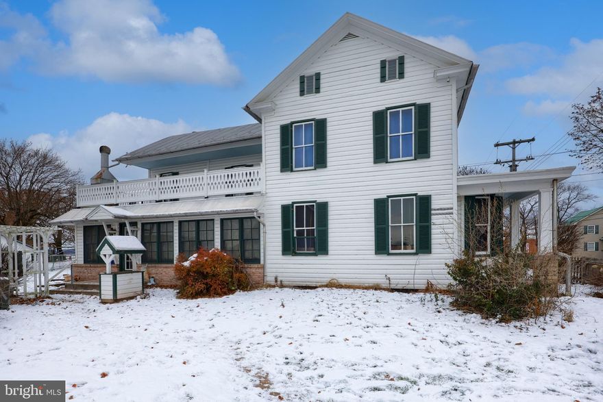 Welcome to this unique and beautiful farmhouse that sits on 3/4 acres with the most breathtaking farm views in every direction you look!  This 4 bedroom, 3 1/2 bath home is filled with rich real hardwood flooring, hardwood steps and woodwork.  Previous owners renovated and started the floor plan to make a Bed and Breakfast. Therefore, each upstairs bedroom has an ensuite bathroom.  Outside, there is a working antique pump from the well encased by a little gazebo. Detached over sized 2 car garage,  and large barn or outbuilding that has a second floor, and a shed that currently hosts turkeys, chickens and a goat.  Boxed in gardens, exterior metal spiral steps from the balcony for fire escape safety or just added charm.  All brick free standing fireplace, great for entertaining! Home has sophisticated modern Septic system that is green, environmentally friendly, 1500 gallons of holding space, a peat moss filtration stage, and a high level tank alarm system. If you ever wanted the feel of living on a farm or the chance at a bed and breakfast, here it is. Schedule your showing starting 12/17/25 as this rare opportunity will go quick!