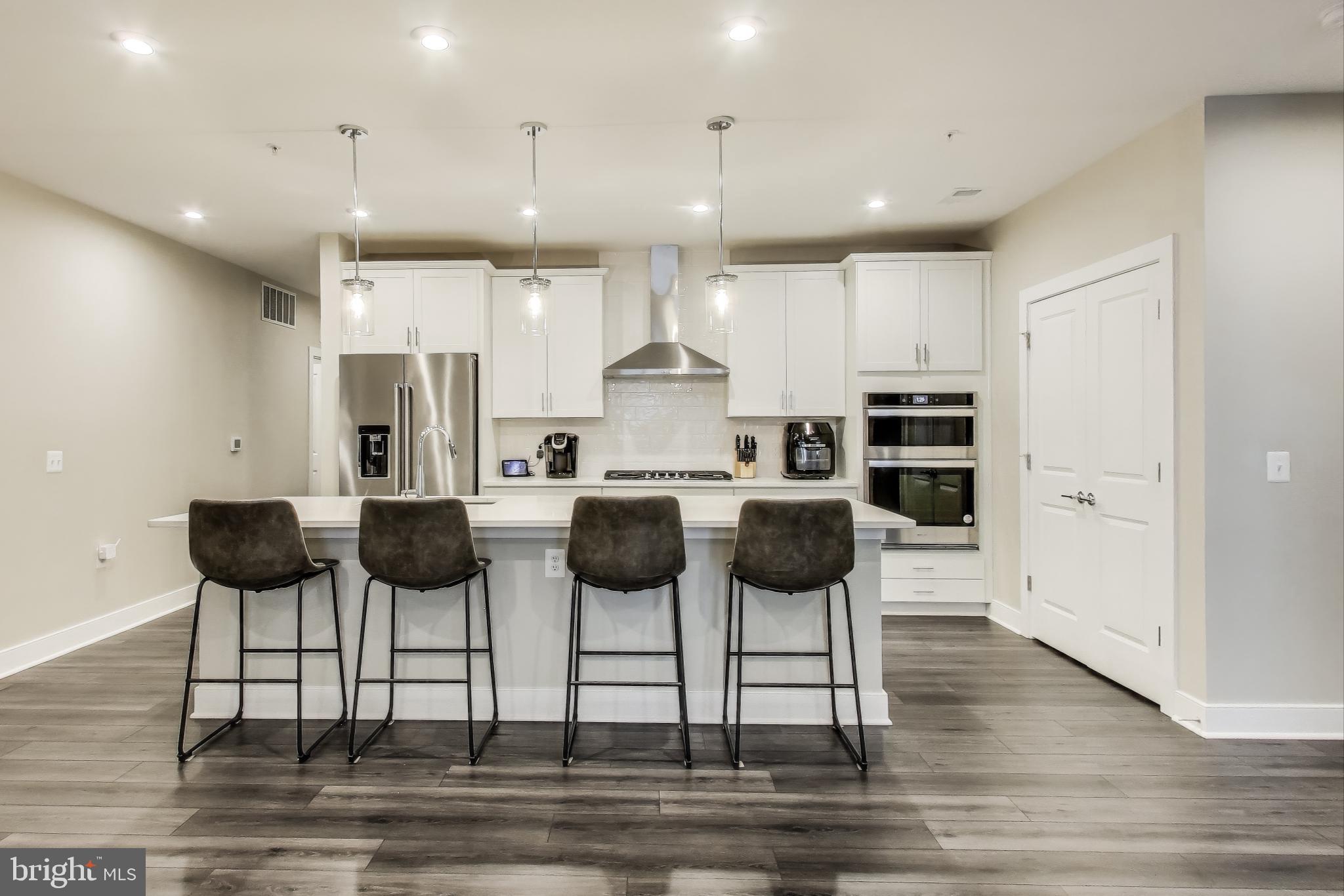 Welcome to a lifestyle of convenience and comfort at this beautiful condo located in the heart of National Harbor. As the largest condo design at The Flats at National Harbor, this expansive 1,798 sf two-bedroom plus den, two-bathroom unit unfolds in an inviting open concept, making entertaining guests or unwinding equally effortless. The kitchen features a sleek island, stainless steel appliances, and a stainless cooktop under a chic hood. The large primary bedroom is replete with an ensuite bathroom that boasts a walk-in shower. Both bedrooms feature walk-in closets custom-designed by California Closets. The condo extends it living space outdoors with a private balcony, ideal for morning coffees or twilight toasts. Separate laundry room and multiple storage options underscore the blend of functional design and modern aesthetics. Two assigned garage parking spots, one with access to an EV charging station, convey with the unit. Book your tour today and come see how luxury, location and lifestyle unite in this amazing property.