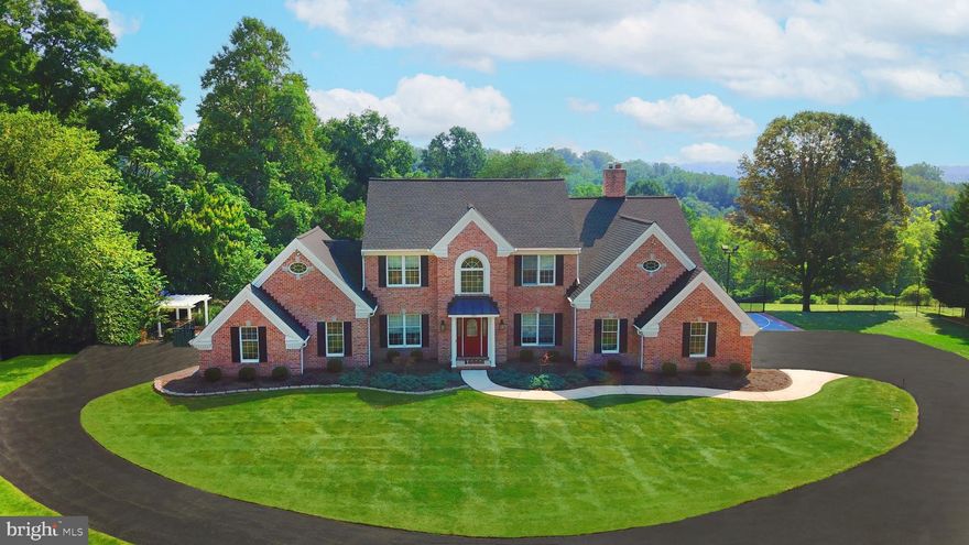 BEST& FINAL OFFER MUST BE IN BY SUNDAY NOV 5 @5PM! Take the shared driveway which leads to this brick front colonial featuring approximately 5,100 fin. SF with 4 bedrooms, 3.5 baths, and 3 finished levels with 9ft ceilings, and 3 garages off a private semi-circle asphalt driveway. Situated on a 2.56 acre lot with a heated inground pool with extensive hardscaping and sports court with overhead lighting, backing to trees. Step inside through the front door to the foyer entry with atrium window and chandelier, crown molding, wainscotting and hardwood floors to the living room, dining room and leading to the kitchen with tile floors. French doors to the study complete with custom built-in millwork style cubbies. Kitchen with granite counters, maple cabinets, panelled Sub-Zero refrigerator, stainless steel appliances, and large glass slider to the extensive rear deck which allows you to take in scenic views. Find a second refrigerator off the kitchen in the mudroom with built-ins. Step down to the family room with floor to ceiling brick wood burning fireplace with beadboard accent wall, luxury plank flooring, plantation shutters and two glass sliders to the deck overlooking the rear yard with heated in-ground pool with patio surround, pergola, and firepit with pavers. Hardwood floors lead up the front staircase to the spacious primary suite with huge walk-in closet featuring laundry room, built-in shelves and private bathroom with maple cabinets, double-sink vanity, jetted garden tub with decorative tile surround, walk-in shower with dual shower heads and bench. Three more spacious bedrooms and full hall bath complete the upper level.  Finished walkout lower-level with wet bar featuring ample cabinet space and dishwasher, full bath with pool access, second laundry room, and slider to the patio with pool and under deck storage, and walk-up to single car garage. Impressive indoor and outdoor spaces designed for all your entertaining needs!