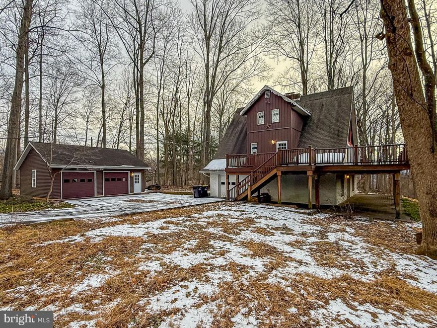 Situated on over 2 acres in the Boyertown School District, this 3–4 bedroom, 2.5 bath home offers distinct character and private wooded views. This property is ideal for those seeking a quiet retreat with plenty of room to grow.  The main level features an A-frame great room with cathedral ceilings and dark wood beams.  Floor-to-ceiling windows and sliding glass doors provides ample light and a connection to the outdoors while the brick fireplace serves as a central focal point of the great room.  As you make your way up the spiral staircase, the flexible layout of the loft offers the versatility for a home office, hobby room, or a fourth bedroom with a full bathroom. Before heading to the lower level, check out the large wrap-around deck overlooking the mature woods and providing the perfect setting for outdoor dining or relaxation. Two bedrooms and a full bathroom complete the main level.  Make your way to the lower level, to solidify this as your next home.  A big recreation room, brick fireplace, and a wall window provide the final touches you seek when you want that extra space to unwind.  A bedroom, powder room, and laundry area complete the lower lever.  For storage and workspace needs, the property includes a detached two-car garage with ample room for vehicles or a workshop. This home is located in an area perfect for the family who loves Sunday drives on back roads, farmland views, and outdoor activities.  Explore nearby Green Lane Park with its hiking trails, fishing, and boat rentals. 1-yr Warranty included with acceptable offer.