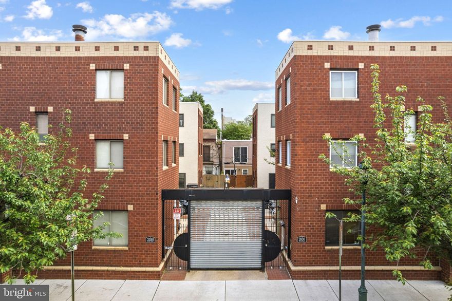 Welcome to 2030 South Street Unit H, a rare opportunity to own a beautifully maintained 2-bedroom, 2-bath townhome tucked within a gated brick-paved courtyard of just eight homes in the heart of Graduate Hospital just steps from Center City and Rittenhouse Square. Freshly painted and full of charm, this home offers dedicated parking directly adjacent to the residence, multiple outdoor spaces, and a unique blend of character and modern comfort. Approach the home through its inviting corner entrance, framed by a front yard with beautiful pavers and a side garden that sets the tone for the warmth found inside. The first floor welcomes you with rich hardwood flooring and a sunken living room centered around a stunning wood-burning potbelly stove with a custom tile surround—creating a cozy and distinctive focal point. Custom inlay blinds with wood trim frame the windows, adding thoughtful detail throughout. The living space flows seamlessly into a bright, well-appointed kitchen featuring light countertops that complement the honey-toned cabinetry, a garden window over the sink, and high-end appliances including a Bosch built-in oven and Miele cooktop with vent hood. A decorative chair rail accent wall adds charm, while two custom white built-ins with drawers and glass cabinetry create the perfect buffet or display area. Sliding glass doors lead directly to a rear deck that is ideal for summer grilling, entertaining, or everyday enjoyment just off the kitchen. The finished lower level provides excellent flexibility, offering additional living space perfect for a den, home office, gym, or media room, along with laundry and ample storage. On the second floor, you’ll find a spacious secondary bedroom with recently updated flooring, along with a versatile bonus landing area—ideal as a home office, sitting room, dressing area, or creative space. A full hall bathroom features a dark vanity, classic white tile, and a tub/shower combination.The top floor is dedicated to the primary suite, offering a peaceful retreat filled with natural light from windows on three sides and two skylights that beautifully highlight the home’s corner placement. This level includes a generous walk-in closet and an ensuite bathroom with dual vanities and a glass-enclosed shower. Quietly set back from the vibrant energy of South Street, yet moments from the Schuylkill River Trail, Fitler Square, and University City, this home offers the best of city living—walkability, convenience, and a true sense of charm and character. Located within the highly sought-after Greenfield Catchment, 2030 South Street Unit H presents an exceptional opportunity to own a unique and inviting home in one of Philadelphia’s most desirable neighborhoods.
