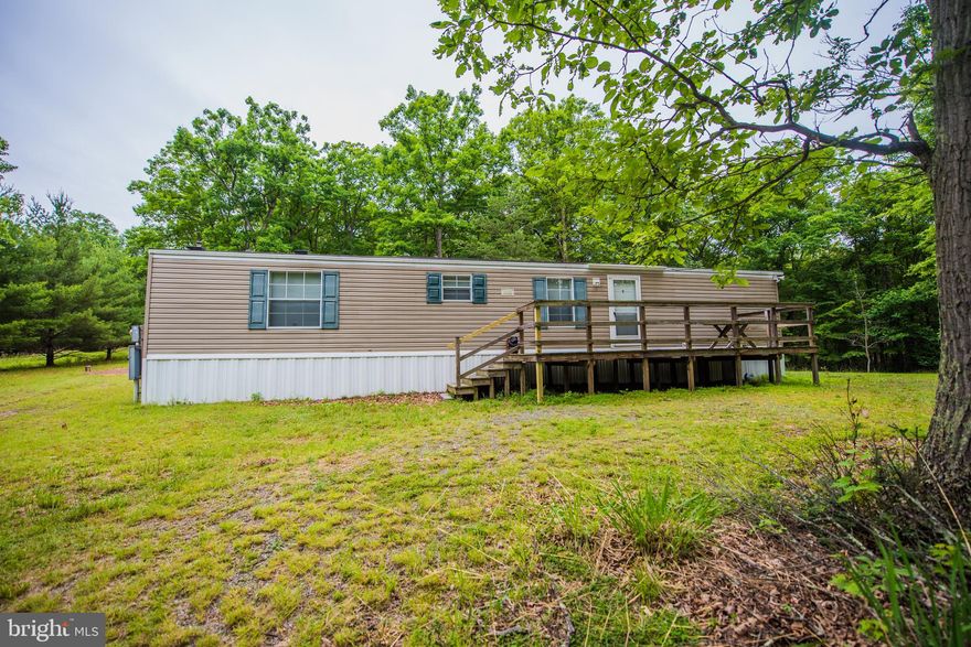 WEEKEND IN THE WILDERNESS in this easy care home with deck nestled on 12.07 wooded acres. Super clean and comfortable 2 bedroom/2 bath single wide including stackable washer and dryer. Central heat and AC. And a nice storage shed. This refreshing retreat affords you snow in the winter, cool air in the summer, nature's beauty all year round. Get away from the city's madness! Call today!