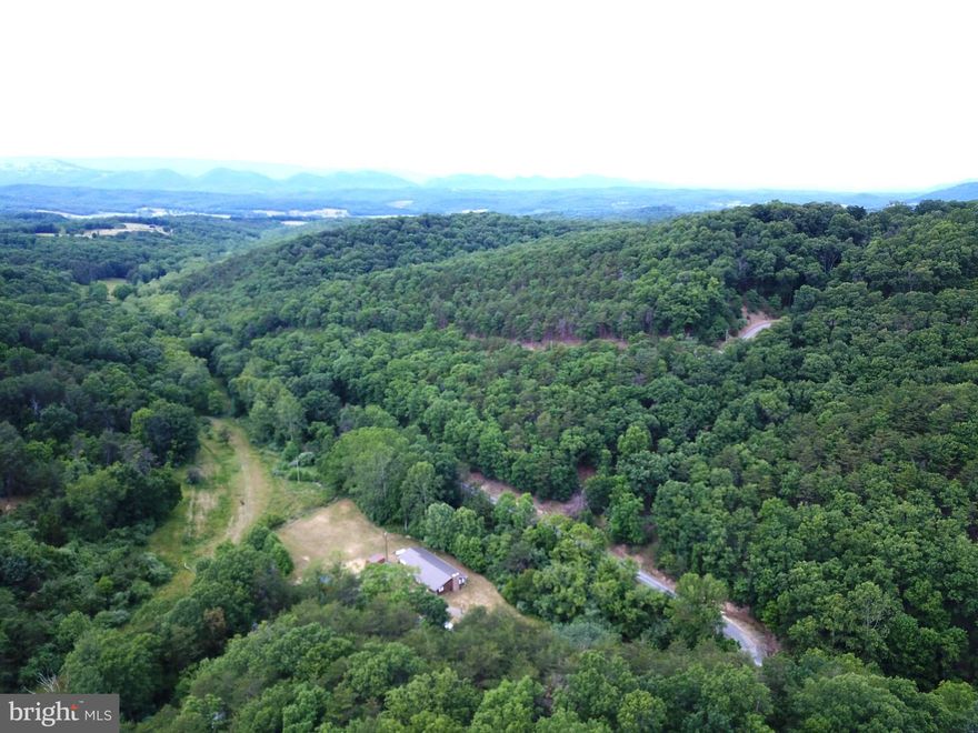 3 BR 2 BA ranch style home "farmette" style property located on +/-20.08 acres in a gated community.  Updated home with open style floor plan.  Stone fireplace with insert.  Whole house propane generator for that extra security.  Exterior of the home could use a little TLC but tons of potential here!!  Fenced area for horses that includes electric fence, small paddock and hay barn.  The Bluffs on the Potomac has a common area for residents with river access (South Branch of the Potomac) and picnic area. Go for a float and enjoy the summer!