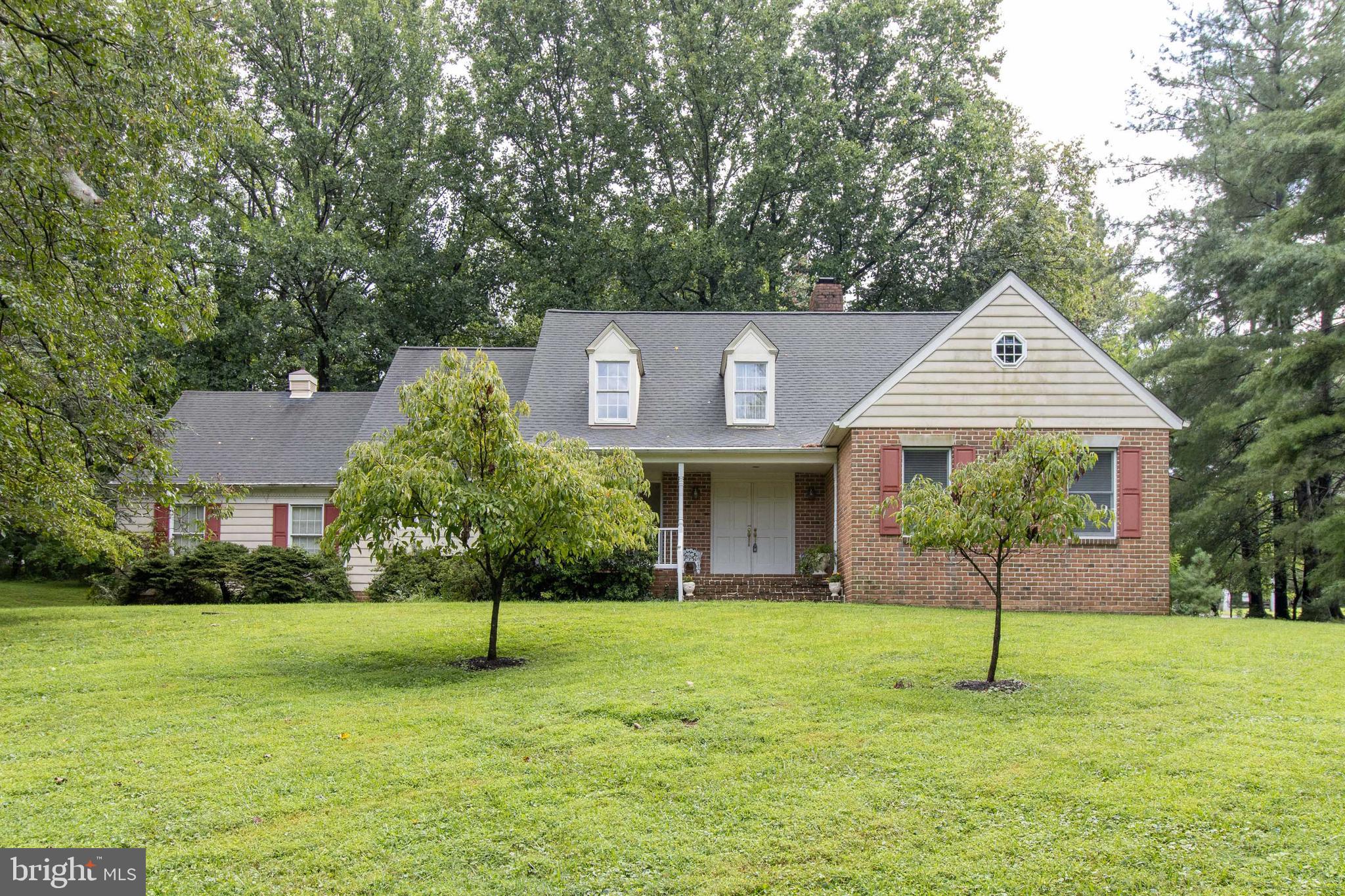 This grand single family home in The Clearings is tucked away down a serene street on just over an acre of land. Driving down the long driveway feels like entering a calm and tranquil escape with the lush greenery and mature trees surrounding the home. A coveted two-car garage awaits! Enter through the lovely brick front porch and into the two-story foyer complete with hardwood floors. The hardwoods carry into the spacious dining room with a chair railing, crown molding, and large bay window that looks out to the front porch. There is ample room to host Thanksgiving dinners for years to come! The large eat-in kitchen has tons of cabinet space, a double oven, a cooktop in the island, and patio doors leading to the backyard. Friends and family won't feel squeezed for space in this kitchen as there is plenty of room to spread out! The laundry room is convenient located right off of the kitchen. Step down into the large family room with hardwoods, a fireplace, a wet bar, and drenched in natural light. Let in the crisp fresh fall air by opening the doors leading onto the back deck. If you are looking for a cozier space to relax you can head back into the den behind the family room! This bonus space has hardwood floors, a fireplace, and opens right up to the sunroom. The spacious primary bedroom is conveniently located on the first floor with more hardwood floors and a separate sink space for getting ready, in addition to the en-suite bathroom. Head upstairs to find three generously sized bedrooms all with their own closet space and lots of windows. Another full bathroom with double sinks is on the second level. The huge basement is partially finished with loads of storage space and a blank canvas for what you need! Saving the best for last - the outside. Take your pick between the sunroom or the large deck! Enjoy a BBQ on the private deck or relax with a cup of coffee in the comfortable sunroom. The backyard is nice and flat with plenty of trees and feels like a country escape! Fortunately you are close to everyday amenities such as 695 and 83. This is a special home that only comes along every once in a while and it's one that you won't want to miss!