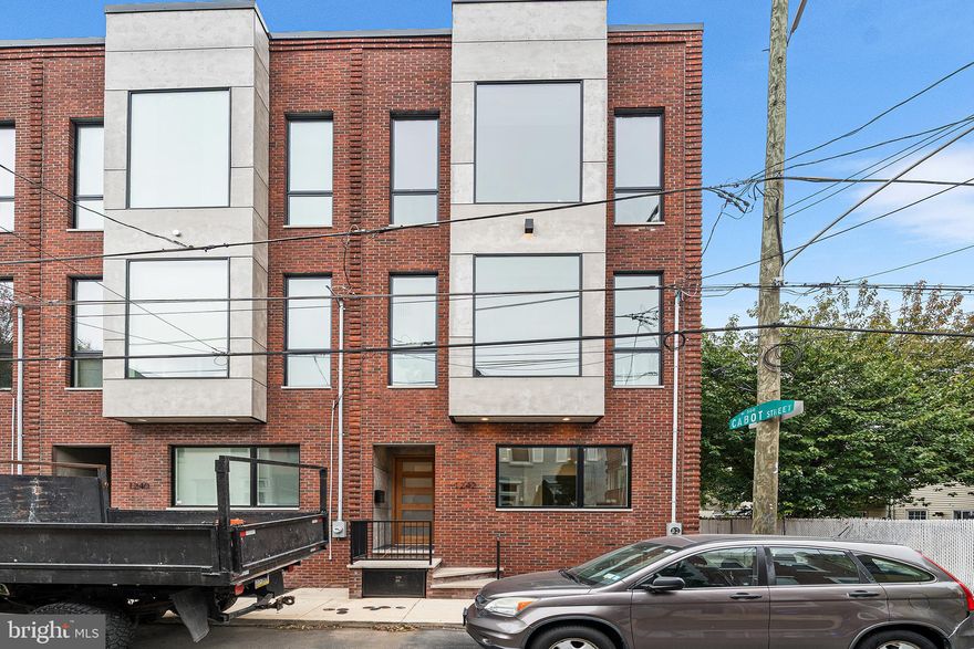 Welcome to the Corner Unit at the Oxford Commons,1242 E Oxford Street. A brand New Construction home with 2 Car Parking and multiple Outdoor Spaces in the heart and center of Fishtown just steps away from La Colombe in Fishtown and booming Frankford Avenue. Originally built as the Developers’s Unit, this home is loaded with upgrades, surrounded by oversized windows, located on a quiet side street and offers a Tax Abatement! This beauty is 5 Beds, 4 Baths, roughly 4,500/SF and an expansive 21 feet wide, a rarity for city living. The 1st floor consists of your 2 Car, side by side, Garage that is large enough for extra storage and equipped with a 220 volt line for your Electric Vehicle charger. Walk into the house and find a mud room, complete with storage and a washer & dryer. A bedroom and a full bathroom are also located on this floor that boasts 10 foot ceilings. Head up the stairs and you will find a huge custom, gourmet kitchen with walnut flat panel modern cabinetry that go from the floor up to the 12 foot ceilings and sit on gorgeous, solid herringbone hardwood flooring  The kitchen boasts luxury Monogram Appliances and a large island with stone countertops and plenty of seating. A custom built banquet with storage sits just across the island in case you wanted to add a table to turn it into a nook. Just off the kitchen is an enormous dining & living space with patio sliding doors (to the rear of the kitchen) not only shedding tons of light in, but providing access to your rear deck. The living room is centered around an open-sided, modern gas fireplace. Head up the custom steel stringer, oak tread staircase up onto the 3rd Floor where you will find 11 foot ceilings, a guest bedroom, complete with it’s own modern bathroom, an additional laundry room, and the luxurious Primary Suite. Step inside the Primary and you will find 2 walk-in closets, a grand bedroom drenched in sunlight, and a swanky bathroom. The bathroom boasts a 9 foot double vanity, private toilet closet and a huge walk-in shower with custom cut marble slabs, dual shower heads, dual rain head, wands and a jacuzzi soaking tub to give you a true spa-like experience. Above the 3rd floor is one of the largest roof decks in Philadelphia with unobstructed views of the city. Downstairs is a fully finished basement with 2 bedrooms, a full bathroom, and a media room/office/ playroom/whatever your imagination desires. 1242 E Oxford St is located just steps away from Fishtown’s best amenities, including; Middle Child Clubhouse, WM Mulherin’s & Son, Kalaya, Suraya, Bastia & so much more.