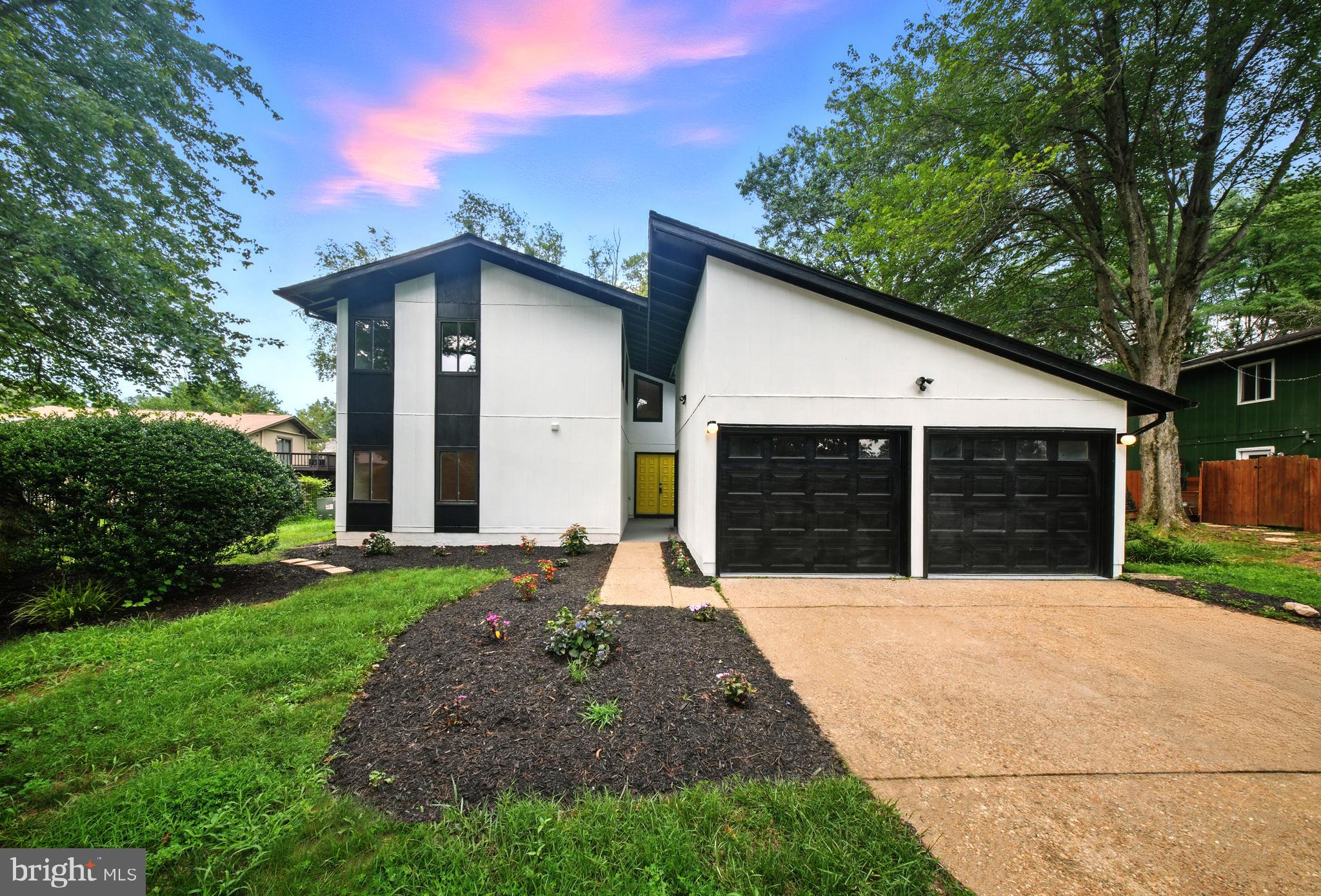Bold, refined, and beautifully reimagined - this Renovated Mid-Century Modern residence is tucked at the end of a peaceful cul-de-sac, offering the perfect balance of architectural charm and elevated, everyday living. With four bedrooms, four and a half bathrooms, and no HOA, this home is a rare find.
The striking black-and-white façade and angled rooflines immediately set the tone for what awaits inside. Step through a vibrant yellow door into a sun-drenched, open-concept layout where wide-plank hardwood floors, and clean modern lines create a cohesive and inviting atmosphere. The chef’s kitchen is an entertainer’s dream, anchored by a sculptural waterfall island and finished with sleek white cabinetry, brass hardware, and a wall of windows that bring the outdoors in. Just beyond, a bold black brick fireplace grounds the living space, offering both warmth and modern edge.
On the main level, you’ll find a private bedroom and full bath, perfect for guests or multigenerational living along with a stylish powder room and a standout laundry room featuring graphic tilework, floating wood shelves, and a built-in dog washing station that’s as functional as it is chic.
Upstairs, the primary suite is a true sanctuary. Shiplap accents, a cozy electric fireplace, and a private juliet balcony creates a calming retreat, while the expansive walk-in closet feels like a boutique showroom. The ensuite bathroom is thoughtfully designed with dual sinks, a dedicated vanity, and a glass-enclosed rain shower that elevates the everyday routine. Two additional upstairs bedrooms each enjoy their own full bathrooms, providing privacy and comfort for all.
Out back, the spacious yard and deck invite relaxed outdoor living, with a storage shed tucked away for added convenience. From its curated interior finishes to its quiet cul-de-sac setting, this home delivers design-forward living without compromise - modern, inviting, and move-in ready.