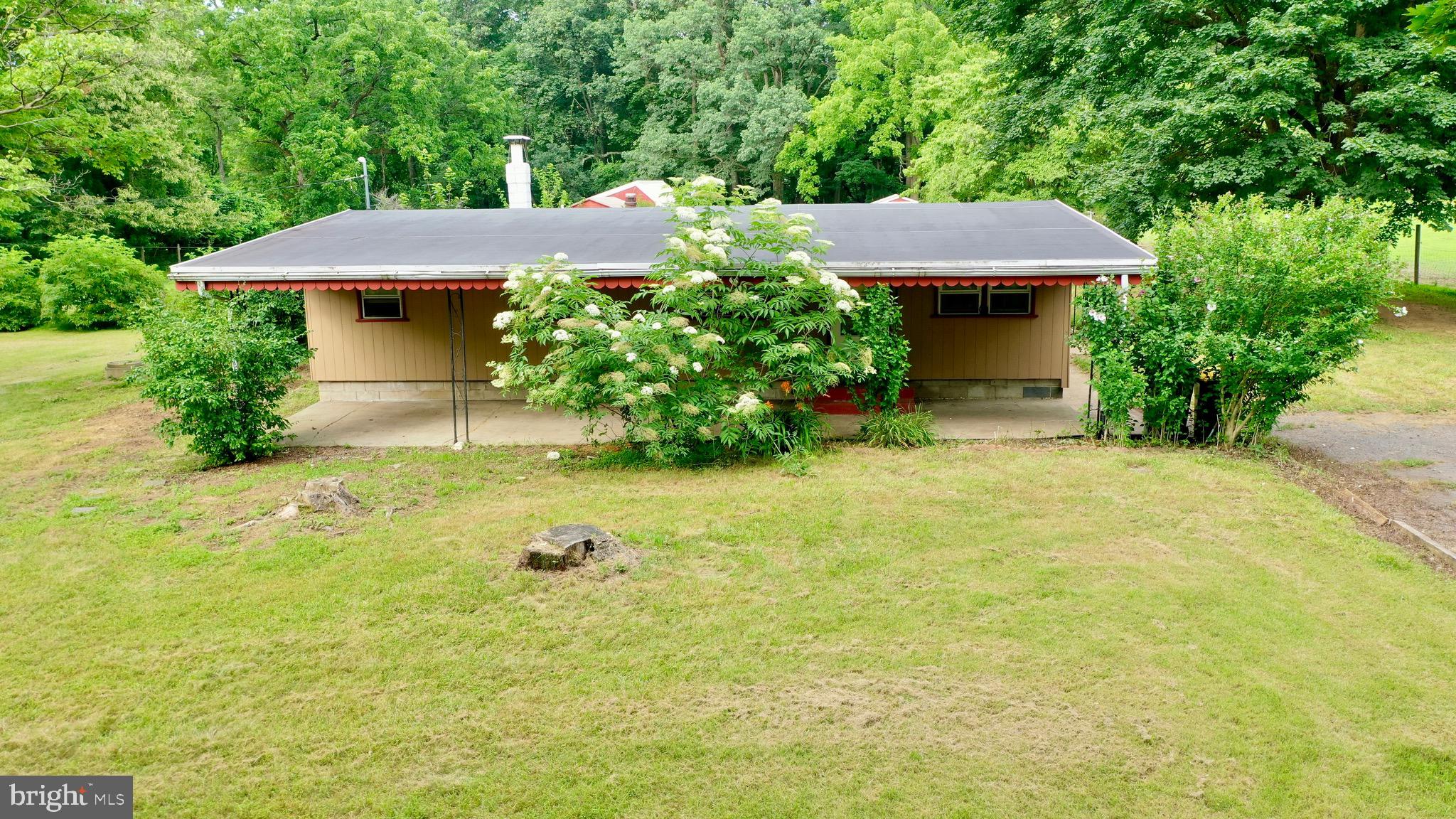 Bring your dreams, ideas and your horses for this property with loads of potential! Check out this gorgeous 2.77 acre lot on a dead end private street. Home recently occupied until 7/1/25 and property was home to two horses and a goat too. This lot is already set up to bring your animals (check with Lower Macungie for the type and amount of animals you can have) with a feed building and stable building. This peaceful lot would work well to live in the 2 bedroom home while you build your dream home too. Home has a full covered front porch and a full rear enclosed sunroom with laundry. Living space inside (sun room) and outside (covered porch) of the home adding to the 820 sq ft. The living room/dining area are open to each other. Currently served by a well and in ground septic system both in working order. The home features 2 bedrooms, 1 bathroom, a full covered front porch and a full rear sun room with laundry. It may be possible to subdivide this lot with expansion of the private roadway too (Check with Lower Macungie Township). Owner is selling AS IS.
