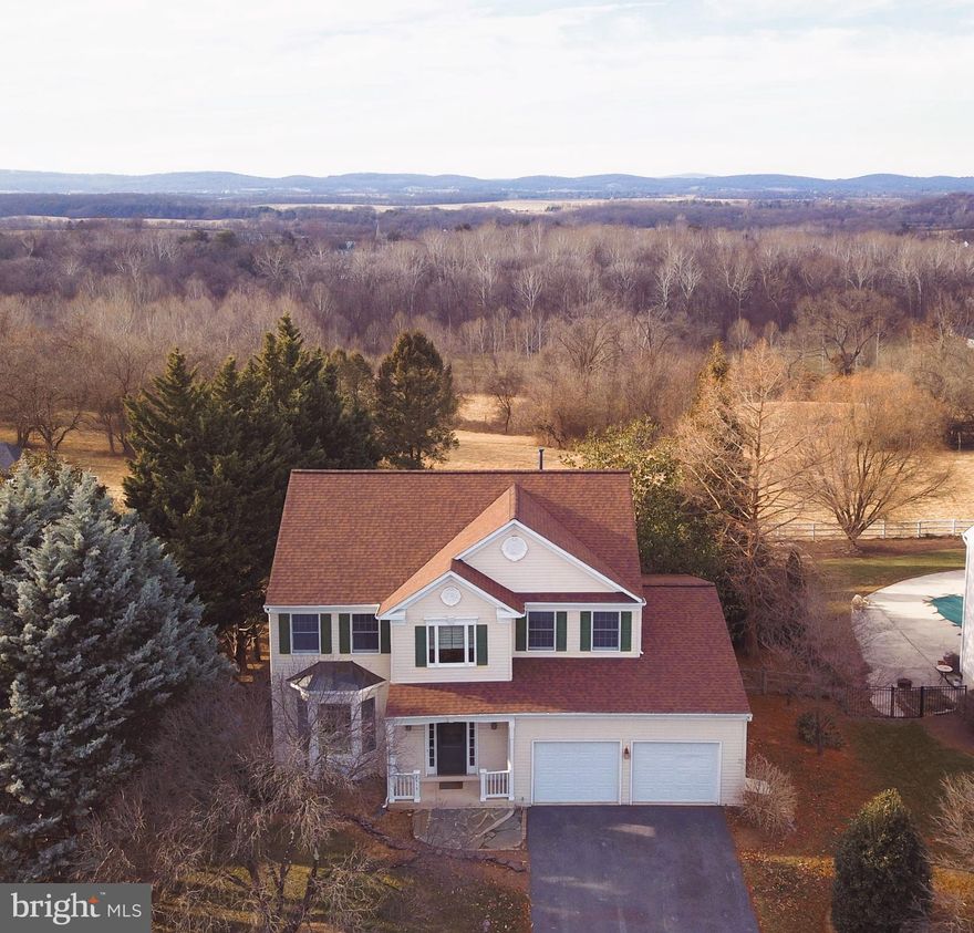 WHAT A VIEW! Location, location, location! Welcome to your next chapter in the heart of Adamstown, 5 Bedroom, 3.5 Bathroom / 2 car garage home awaits its new owners! This classic design offers a spacious main level complete with a 2 story foyer with hardwood staircase, hardwood flooring, formal living room, formal dining room, gourmet kitchen with granite tops & separate island, and large family room with cozy gas fireplace. The upper level offers a grand master suite with cathedral ceiling, ensuite luxury bath with dual sink vanity, separate soaking tub & separate tile shower, 3 additional secondary bedrooms & 2nd bath with oversized vanity. The walk out lower level  features  a large rec room with wet bar, 5th bedroom, & 3rd full bath. Private backyard is fenced with many features including a flagstone patio, mature plantings, shed, &  expansive rear pergola / deck with stunning  panoramic views of rolling pastures & mountains. Roof is 1 year old. Great location only 5 mins from 1-270 & close to shopping & restaurants. Seller prefers Friends Title & Escrow