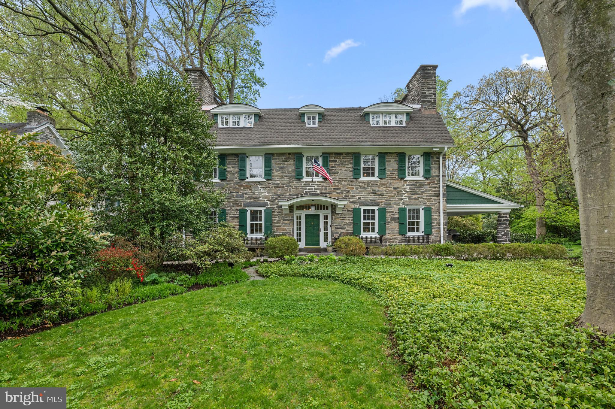 Tucked away in northside Ardmore, is an elegant 3 story stone Colonial on a beautifully acre (+/-) manicured lot. Built in Circa 1900, this home offers old world charm with today’s modern amenities, walk to the Ardmore Train Station, Suburban Square, restaurants and shops. Wow!!
Gracious Entry Foyer welcomes you, a grand staircase, gleaming hardwood floors, detailed moldings, deep windowsills and French doors throughout the main level. Formal Living Room with gas marble fireplace, and outside exit to covered patio perfect for entertaining. Formal dining room with marble fireplace, gourmet eat-in kitchen, soapstone counters, stainless steel appliances including a Miele dishwasher, double oven, Sub Zero Refrigerator, double sinks, center island seating for four, Viking gas cook top w/griddle and Dacor fan, microwave, island sink, recessed lighting, pantry closet, plus cabinets galore. Back staircase to the second floor landing and additional staircase to the basement! Kitchen opens into a skylit breakfast room and great room with floor to ceiling windows, built-ins, entrance to slate patio, Office with custom built-ins and desk, second den features screened in porch, mudroom, 1st floor laundry w/Bosch washer and dryer plus Powder Room. OE to driveway, detached 2 car garage and parking for 6+.
2nd Floor offers spacious owners’ suite w/fireplace, spa-like bath w/soaking tub, walk-in shower, double sinks & vanity. Dreamy screened in porch, dressing room with custom built-ins and closets. Two additional large bedrooms with fireplaces, linen closet and hall bath complete the 2nd floor.
3rd Floor provides a 4th bedroom with custom window seats, ensuite Bath with clawfoot tub, 5th bedroom currently being used as an office with pocket doors to a bonus room, possible 6th bedroom or sitting area, walk-in cedar closet, and Hall Bath.
Freshly painted basement includes second laundry area w/washer and dryer, plus a fabulous temperature-controlled Wine Cellar with 1300 – 1400 bottle capacity, built-in wooden racks, center marble-topped bar with additional storage.
Additional amenities feature new house roof in 2019, exterior freshly painted 2022, 3 Zone Heating and cooling, Rachio Wi-Fi smart lawn sprinkler controller (panel) for the entire property, whole house Gas Generator, Motion-Detector LED Lighting surrounding home and garage, Ring Doorbell System for front door and driveway, Electric Entry Security Gate, Alarm System and much, much, more!