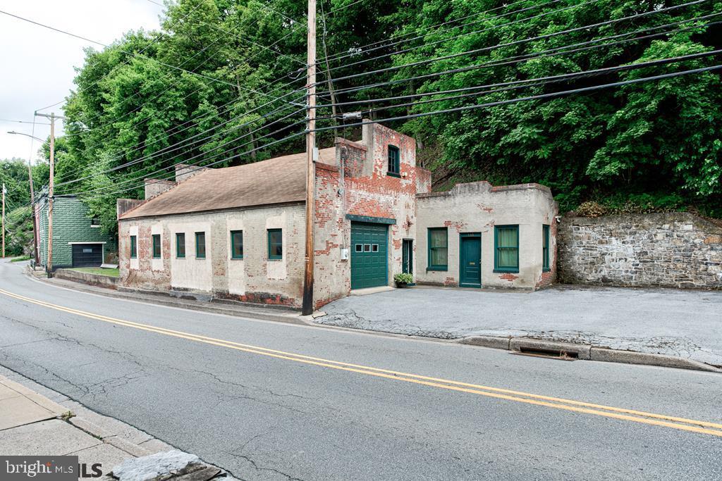 FOR SALE a historic and spacious commercial property with a clear span interior that can accommodate cars and trucks end to end with entry and exit at each end. On site parking (inside and out) and high traffic visibility. On-site office and restroom. Bright windows, high ceilings make for bright, airy work environment.