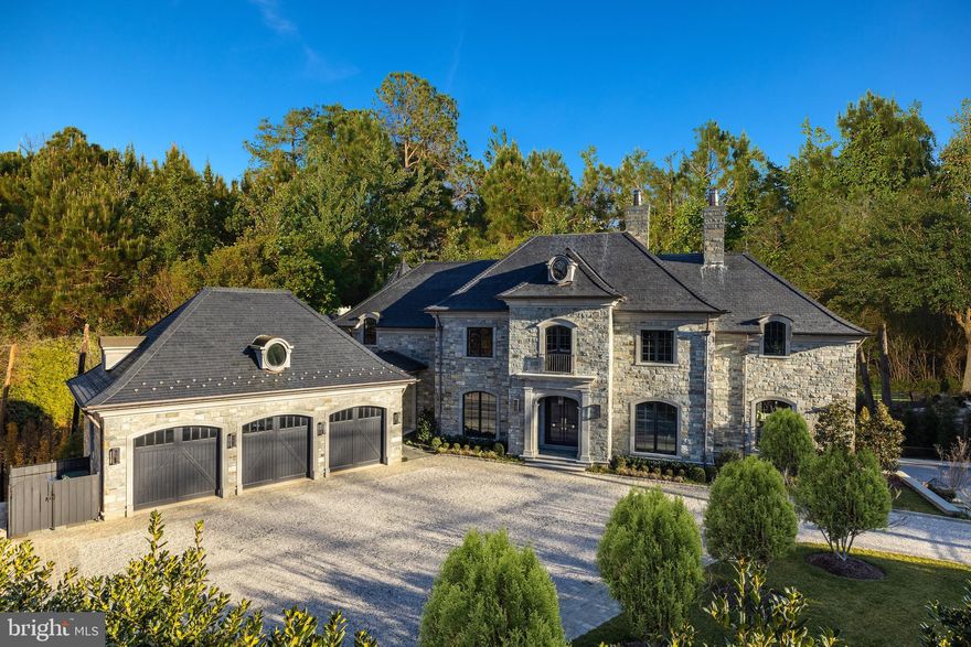 A bespoke architectural masterpiece tucked away behind a circular driveway on one of the District's most posh and coveted streets, 2425 Foxhall Road exudes grandeur, appeal, and classical European flair from its captivating stone facade to its expansive, lofty interior. Prominently sited on over an acre of fully secure and gated lush grounds, the home offers an urban oasis with unrivaled privacy, sunlight, and dramatic, unencumbered views of the surrounding wooded hillsides. Through countless thoughtful design choices inside and out, the home exemplifies the ideal contemporary amenities and floor plan of a newly built residence while retaining the privacy, sophistication, and splendor of a centuries-old estate. ​Grand-scale, sun-drenched rooms throughout the interior feature tall ceilings, many custom architectural details, and serene, leafy views from every window. Ideal for entertaining, on the main level, a large dining room, walnut paneled drawing room, and airy open kitchen/family room flow seamlessly together and outdoors to the surrounding terraced gardens and south-facing loggia, pool, and outdoor entertaining space. 7 bedrooms, each with en suite bath and ample closet space ensure extensive privacy for family and guests. 2 large study/offices, a sizable lower level great room with wet bar, and a cedar dojo/exercise studio add to the plentiful work, family, and entertaining space. A 3-car garage with breezeway entrance to a main level mudroom and cobblestone motor court ensure sufficient and easy parking.