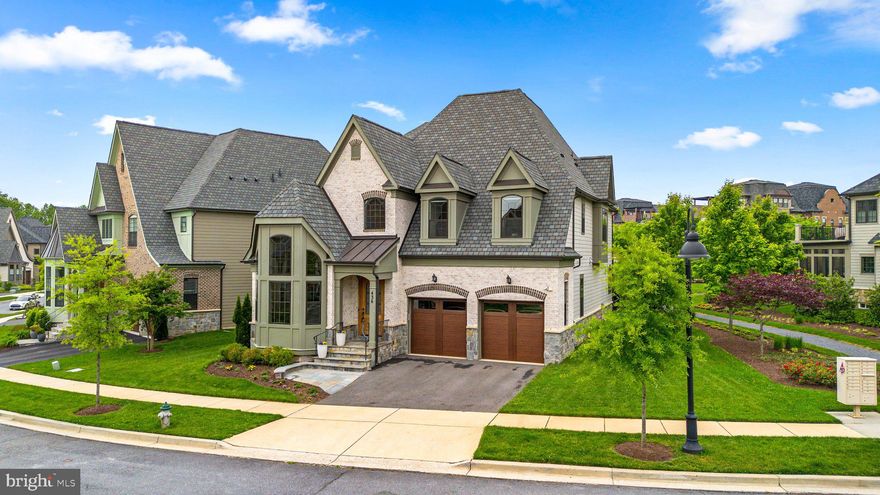 The rarely available “The Estate Home” built by award-winning builder, Wormald Homes, presents living on a grand scale with a two-story entrance gallery and 10-foot ceilings. Espresso wood floors cover the entire main level beginning with the home office, highlighted with a palladian window bump out, built-in bookcases, cathedral ceiling, and French door entry. The rest of this level is skillfully designed with entertaining in mind. The formal dining room is accentuated with a dropped ceiling feature and architectural pillars, making a beautiful setting for dinner parties & holidays. The perfectly designed Chef’s kitchen allows you to prep, serve & entertain with ease. Features include high-end Viking stainless-steel appliance package, pristine quartz that covers the countertops, backsplash, and waterfall edge island, excellent prep & work-flow areas, and walk-in pantry storage. The spacious kitchen also includes room for informal dining and overlooks the great room, anchored by the aesthetically pleasing gas fireplace and arabesque tile surround. Interested in adding a future elevator? Relocate the powder room to the extra storage area and have an elevator shaft retrofitted in its place. 
Upstairs, you will be amazed by the luxurious primary suite with its soaring 14-foot ceiling, dual walk-in closets, and access to the private roof terrace. The primary bath has pocket door closure at the entry and water closet and features separate vanities, 2-person soaking tub, and dual head stall shower. Four large bedrooms, each equipped with a private full bathroom and convenient upper-level laundry complete this level. 
Heading all the way downstairs, you are greeted with the lower gallery that opens to the sprawling recreation room with a full-size wet bar, making this an excellent space for watching sporting events or entertaining friends. 5th bedroom, 5th full bath, tons of storage space, and a flex room that can transform into a theater room, exercise room, playroom, craft room, office, you name it. 
Enjoy fluid transition between indoor & outdoor living on the rear screened porch with the most beautiful view of the meticulously landscaped Steinbeck Park, and pop on over to the deck for summertime barbecuing or sunbathing.
The Crown neighborhood showcases a community clubhouse called “The Retreat” where residents can enjoy a beautiful facility with sun decks, a rentable party room, rock climbing wall, inground pool, tennis courts, and playground. Just a short distance from vibrant Downtown Crown, you can live effortlessly with modern-day conveniences within your reach. Enjoy dining at the premier restaurants that anchor Downtown Crown—Ruth’s Chris Steak House, Coastal Flats, Paladar, Ted’s Bulletin, Asia Nine, & Ted’s Montana Grill, and relish in the convenience of having a grocery store (Harris Teeter), coffee shop (Starbucks), banking (Wells Fargo & Navy Federal), shopping (Sephora, Lululemon), and luxurious spa (Woodhouse Day Spa) all within your neighborhood.