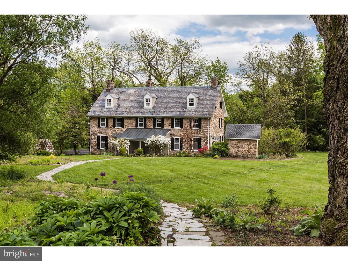 This c. 1749 stone manor house is part of a complete, quaint farmstead that includes a stone and frame carriage house, stone spring house with pond, smoke house and two frame barns. Situated on 3.85 acres, the main home's scale and room dimensions suggest it was built by a person of means. Previously serving as a bed and breakfast, this house offers six en suite bedrooms and a series of expansive first-floor living spaces. Fireplaces, including the original walk-in fireplace offered as-is, deep window sills and wide pine board floors add to its appeal.  The property has been freshly painted and a second-floor laundry has been added. The carriage house is suitable for use as a home office or studio. Located in the old barn ruins is a two-tiered, in-ground pool perfect for warm-weather entertaining. With the variety of historical structures on the grounds, perennial gardens and mature trees, this property has great potential to be a private residence and showplace or it can continue on as an inn in the B&B/VRBO/AirBnB manner, as its location is perfect for those coming to Bucks and Hunterdon Counties for getaways with Peddler's Village a few minutes away and New Hope, Lambertville, Stockton and Doylestown just a short drive. U.S. News & World Report ranks New Hope-Solebury HS #2 in the state making this a highly desired school district.