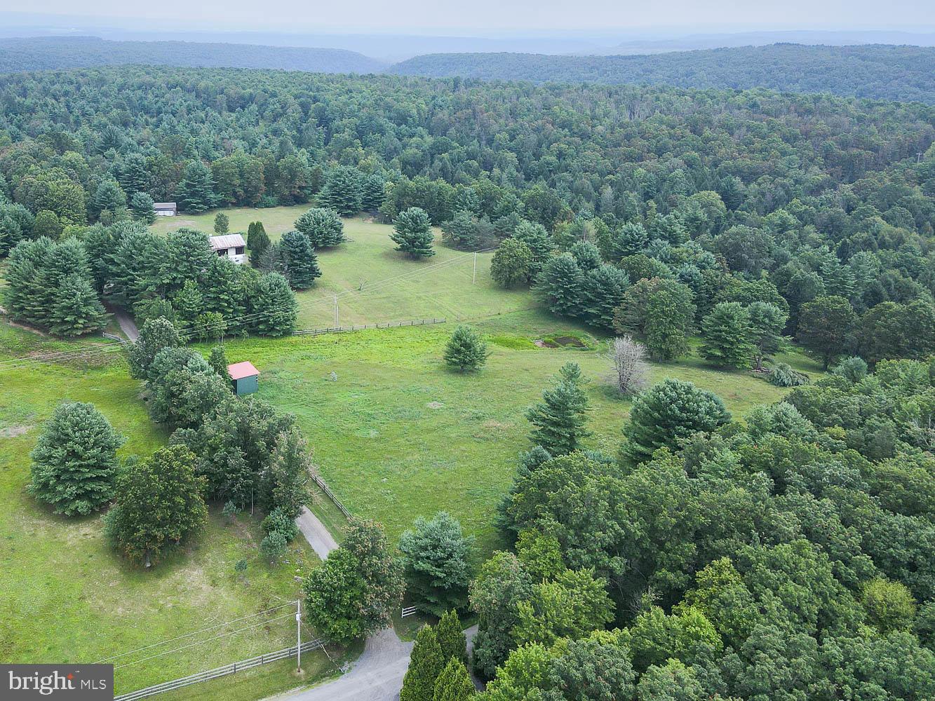 Peaceful Country Retreat on 17 Acres. Tucked away at the end of a quiet dead-end road in the heart of rural Central Pennsylvania, this private 17-acre haven offers the peace and seclusion you’ve been searching for. Surrounded by nature, the rustic log-style home boasts 5 bedrooms and a full bath, providing ample space and endless potential to transform into your dream country escape or permanent residence. The interior is a blank canvas, ready for your personal touches. Imagine cozy evenings by the fireplace, family gatherings, and the simple joy of country living. Step out onto the charming covered rear porch and take in the serene landscape, perfect for your morning coffee or winding down after a long day.
Outbuildings on the property provide excellent shelter and space for your horses, cattle, or other livestock, making this an ideal setup for a Farmette lifestyle. Whether you're looking to start a hobby farm or simply enjoy wide open spaces, this property is ready to bring your rural living dreams to life. OGM rights will convey.
Enjoy stunning country views, wide open skies, and a sense of calm that only comes with rural living. Whether you're seeking a peaceful weekend getaway or a full-time retreat, this property is brimming with potential.