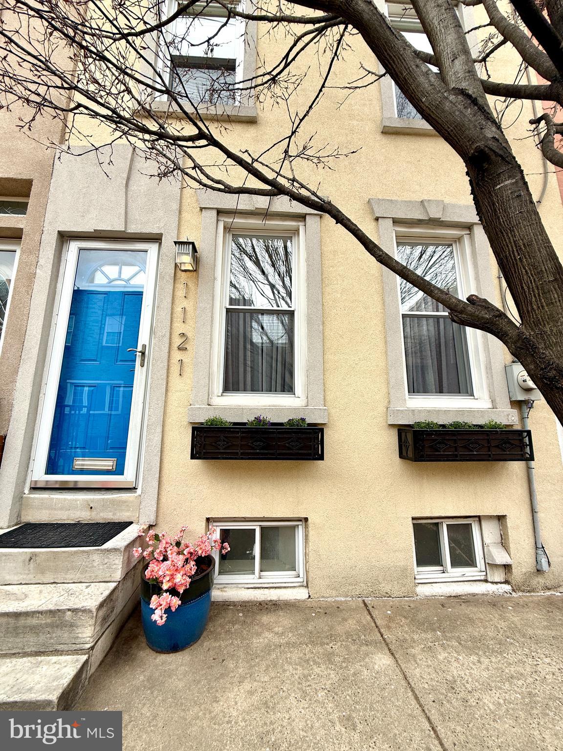 Extra charming and extra lovely in Passyunk Square! Spotlessly clean, recently updated and fashionably appointed, this home blends cozy and contemporary with details that include central air, hardwood floors throughout, built-ins gilding the living room, and custom finishes in the kitchen. Southwestern light streams through the front windows, highlighting the open, airy layout of the living/dining room. A full, tiled bathroom with a stall shower conveniently separates the kitchen from the dining area. The kitchen features reclaimed wood accents and heated floors, and beautifully coordinated wood shelving and cabinetry. The back patio is perfect for gardening and lounging, with plenty of room for a lounge set and grill. Upstairs, the primary bedroom enjoys plenty of space and natural light. The second bedroom awaits your guests, kids or home office. And the second full bath is comfortably equipped and clean, and offers shelving for linen storage. The clean, dry, unfinished basement has plenty of room for storage and laundry. Nestled on one of the sweetest side streets of Passyunk, this home features an absolutely perfect location: just one block away from Columbus Square park, Passyunk Avenue's shops and restaurants. Move right in!