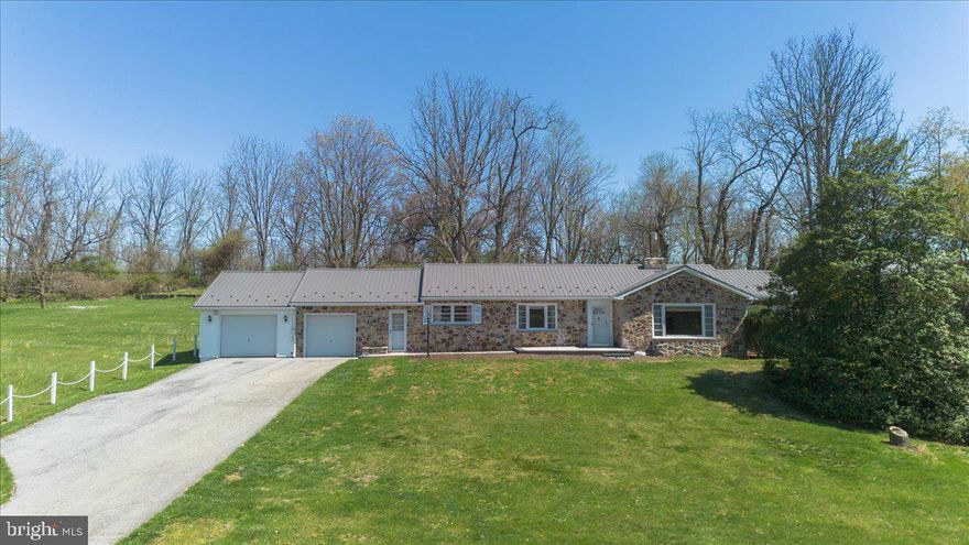 Privacy, breathtaking views, and timeless stone construction come together in this exceptional property, complete with an additional building lot and wooded acreage.
Set on a total of 1.89 acres across two parcels, the main home rests on a 1-acre lot, while the adjoining 0.89-acre wooded lot offers added space, flexibility, and opportunity. Whether you’re dreaming of gardening, raising chickens or livestock, or creating your own homestead, this property delivers the ideal setting.
The second lot includes a small shed/barn—perfect for storage or easily adaptable for animals. A unique and versatile water system features both a well and a cistern with rainwater recapture. The setup is fully customizable, currently configured so the well supplies sinks, showers, and laundry, while the cistern services outdoor spigots and toilets.
The home’s solid stone exterior is complemented by a new paver stone walkway and patio, enhancing its curb appeal. Inside, a central foyer with hardwood floors welcomes you and connects the main living spaces. To the left, you’ll find a formal dining room leading into a well-appointed galley kitchen with ample cabinetry and storage. To the right, the formal living room features a large picture window and a classic stone wood-burning fireplace, with an adjacent space ideal for a home office or den.
This home offers 4 bedrooms and 1.5 bathrooms, including a primary bedroom with hardwood floors, dual closets, and a private half bath—with potential for expansion into a full bath.
A standout feature is the main-level 3-season sunroom, complete with ceiling fans and three walls of windows overlooking the peaceful, private backyard—perfect for relaxing or entertaining while enjoying the surrounding nature.
Additional highlights include two front-loading garages, with cistern access conveniently located in one and a system that allows rainwater diversion once the cistern is full.
The lower level expands your living space with a large recreation room and family room, both featuring stone floors. The rec room includes a wet bar, paneled walls, and another stone wood-burning fireplace—ideal for gatherings. The basement also offers three additional rooms for laundry, utilities, and mechanicals, along with walk-out access to the rear yard.
The additional lot may offer the potential to build a second home (subject to perc testing and county approval), providing even more opportunity for future expansion or investment.
Recent updates and improvements include: Metal Roofing in 2023, new front walk and patio in 2025, new furnace and central air in 2019, replaced hot water heater in 2019.
Conveniently located with easy access to I-70 and major commuter routes, and just minutes from Meritus Medical Center, Hagerstown Community College, Washington County Regional Park, and Black Rock Golf Course, this property offers the perfect balance of privacy and accessibility.