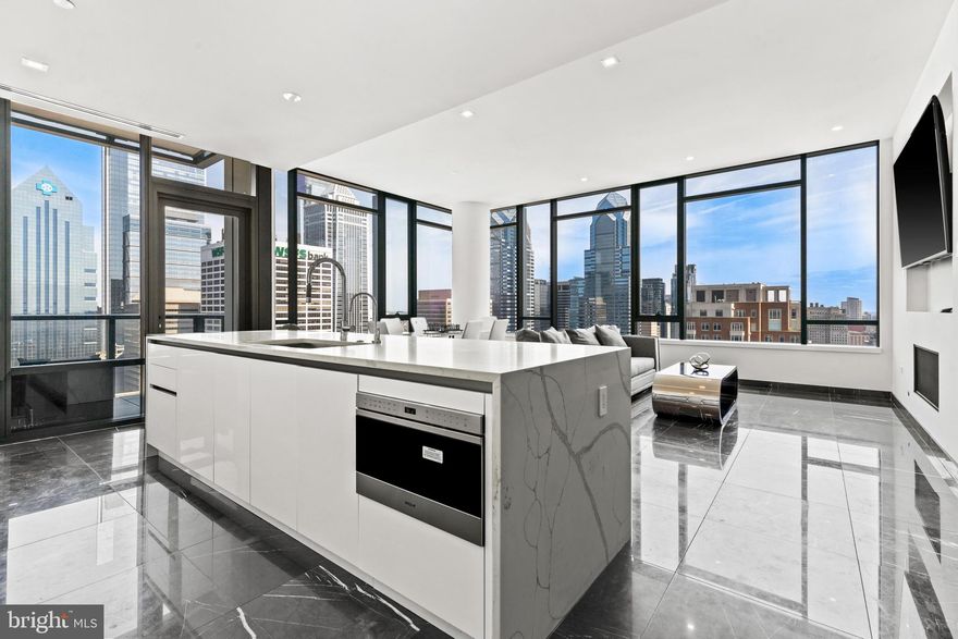 Welcome to The Laurel - Philadelphia’s Pinnacle of Luxury Living on the Square. Step into unparalleled elegance with this fully upgraded Sky Residence at the 33rd floor of The Laurel, Rittenhouse Square’s crown jewel. This exclusive residence has been thoughtfully enhanced with the most opulent finishes available, black marble flooring throughout, two private balconies offering stunning outdoor escapes, and a custom-designed Tribal Makassar wet bar that elevates the art of entertaining. This expansive 2-bedroom 2.5 bath residence captures breathtaking views with floor-to-ceiling wraparound windows showcasing vibrant sunsets over the park from the primary suite and incredible city views from the living room balcony. Spanning 1750 square feet with soaring 10-foot ceilings, this home is the epitome of refined luxury city living. The gourmet kitchen is a modern masterpiece, featuring sleek European cabinetry, quartz waterfall island, and top-of-the-line appliances including a Sub-Zero integrated refrigerator, Wolf gas cooktop, convection and steam ovens, Miele dishwasher, and drawer microwave. The adjacent open-concept living and dining areas are ideal for both intimate evenings and grand entertaining, especially with the seamlessly integrated, custom-upgraded wet bar. The primary suite is a serene sanctuary boasting balcony access, a spa-inspired bath with radiant marble floors, a freestanding soaking tub, floor-to-ceiling porcelain tile, and an expansive glass-enclosed shower with designer fixtures. Residents of The Laurel enjoy a host of white-glove amenities: 24-hour concierge, valet service, a state-of-the-art fitness center, indoor and outdoor saltwater pools, a luxe club room, and a landscaped terrace with panoramic views overlooking historic Rittenhouse Square. One deeded parking space is included. Additional parking options available upon request. Elevate your lifestyle schedule your private tour today.  72 hour notice required for showings.