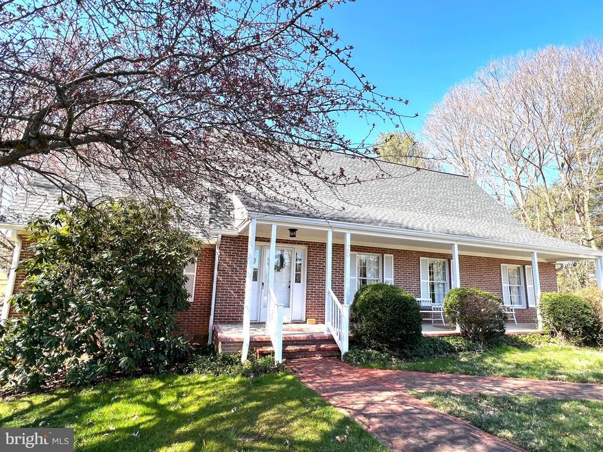 A Heavenly property on 2 gorgeous treed and landscaped acres in a  peaceful  neighborhood cul de sac 2 minutes from historic Shepherdstown.  The perfect combination of mature trees (including Dogwood, Crabapple, Poplar, Pines, oak, Walnut and  huge beautiful Magnolias  bursting with buds) forsythia, daffodils, tulips & wildflowers surrounding  open grassland spaces and gentle sloping  yards with plenty of spaces for gardens and recreation. This is a bird and nature lovers paradise, w space for  year round family activities. 

The handsome brick two story home with hardwood floors, new roof (50 yr warranty)and finished walk out basement plus new water filtration system,  features 3 bedrooms and 3 1/2 baths.  The Primary bedroom suite is on the main level w/ walk in ‘his & her’ closet,  full  bath incl walk in, tiled, glass door shower w rain head, a beautiful marble vanity w/ wood cabinetry below, and large linen closet. This main level  bedroom has tall windows w views to the back upper deck and woods.   

Two  wide curving custom houndstooth pattern brick pathways lead from the driveway to the covered
 raised brick and concrete front porch which extends across the entire front of the home.  Landscaping  and trimmed boxwood add a special welcome feeling along with three exquisite  custom brick circular design patterns laid into  the porch  itself.  

The home’s front entrance offers a tiled foyer, and hardwood floored central hall with space for a bench and coat racks.  To the left you’ll find the Primary bedroom suite & full bath and lushly carpeted stairs to two  large upper level  bedrooms with closets, tall windows, & full bath.  The largest upper level bedroom offers extra space for sitting/dressing and a double door closet plus a laundry chute to the main level laundry room. The upstairs also has a shelved hall linen closet.

To the right off the main hall, lovely glassed French doors lead into the large formal Living room w tall windows and hardwood flooring, then through the archway on to the formal dining room w chandelier and more light through tall windows. The dining room also opens back  to kitchen area and  hallway to side door  entrance deck to home.
 
The main hall continues  back to the cozy family room with recessed lighting and a  woodstove on its  raised brick hearth & floor to ceiling brick wall behind.  Double insulated glass door and screen door lead to an outstanding screened entertainment deck, aprox 33’ x 16’ w two ceiling fans in a vaulted ceiling.  This wonderful deck overlooks woods and yard and has another  door to the second upper deck with stairs to the lower level yard and walk out bsmt. 
Adjacent to the family room is the kitchen with its plentiful array of contemporary white cabinetry , large sink in white laminate counters looking out to family room.  Nice views to back deck and yards. Extra large built in microwave !
A convenient laundry/ mud room and half bath are off the hall leading from kitchen to side entry to home.  Hardwood floors  throughout !

Interior stairs  lead to the spacious partially finished walk out basement area featuring a separate wood shop room, large rec room  and  ofc area plus two rooms suitable as bedrooms, guest rooms or offices.    A full bath rounds out this additional bsmt space.  The rec room walks out to a well maintained under deck mulched area w pavered walkway to  back yard with its double door larger sized tool shed.  

Dreamy location a few minutes from historic Shepherdstown offering a  beloved beautifully landscaped 
3 bdrm, 3 1/2 bath brick home w/ walk out finished bsmt on 2 acres among the trees, flowers,  meadows and birdsong ready to welcome its next family.