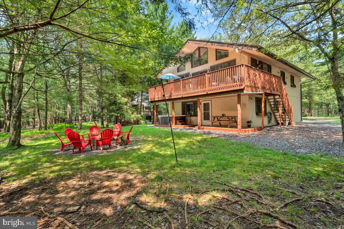 Welcome to your mountain retreat in the heart of Lake Harmony Estates! This stunning 5-bedroom chalet offers the perfect blend of rustic charm and modern comfort, just minutes from Jack Frost and Big Boulder ski resorts. Step into a bright and welcoming great room with soaring cathedral ceilings, abundant natural light, and a cozy propane fireplace. The open floor plan flows seamlessly into the dining area and updated kitchen, featuring leathered granite countertops and a breakfast bar. The main level offers two comfortable bedrooms, a full bath, and access to a spacious deck overlooking the wooded backyard and fire pit area, ideal for outdoor gatherings or quiet relaxation. The lower level expands your living space with another propane fireplace, a game room with pool table, a kitchenette, three additional bedrooms, and a full bath. Outside features a hot tub on the lower deck and a fire pit area. Set on a corner lot with a wrap around driveway, this home offers both convenience and space! As part of Lake Harmony Estates, you'll have access to a motorized lake and beach, and with endless activities nearby including water sports, hiking, Pocono Raceway, white water rafting, shopping, and the historic town of Jim Thorpe. Whether you're looking for a vacation home, investment property, or year-round residence, this chalet is a true Pocono gem!