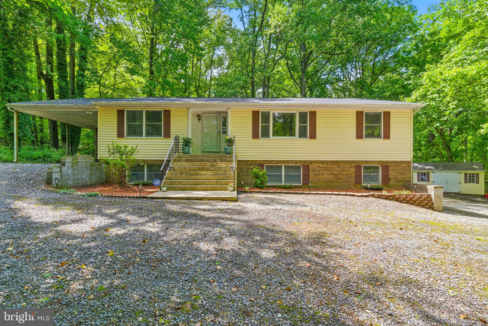 Welcome to this expansive and beautifully maintained oversized rambler with over 3,400 SQ FT of living space, ideally set on over 3 acres of serene, wooded privacy. Big ticket updates include: New roof, new gas furnace, new central air and new carpet in basement all within the last year. Featuring a Side-load two-car garage and additional carport, this property offers both functionality and space. A large screened-in porch on the side of the home creates the perfect setting for enjoying peaceful mornings and relaxing evenings surrounded by nature. Step inside to discover bamboo hardwood flooring throughout the main level, beginning with a welcoming foyer and coat closet. The formal dining room features a large picture window, crown molding, chair rail, and gleaming hardwoods—perfect for hosting gatherings in style. An open and inviting family room is bathed in natural light, thanks to a tubular skylight, and showcases rafter ceilings, a ceiling fan, and newer double-pane bay windows. The spacious eat-in kitchen offers an ideal layout for both daily living and entertaining, with an electric cooktop, wall oven, stainless steel dishwasher, refrigerator with water and ice, stainless steel double sink, recessed lighting, and a ceiling fan. A cozy dining nook and direct access to the screened-in porch enhance the home's indoor-outdoor living appeal. A convenient laundry area is tucked just off the kitchen with full-size, front-loading washer and dryer. The main level includes 3 generously sized bedrooms and 2 full baths. The owner’s suite features a ceiling fan, walk-in closet, and private en-suite bath, while the additional guest bedrooms share a hall bath with dual-sink vanity and a jetted soaking tub. Other thoughtful features include pull-down attic access with partial flooring and a whole-house fan for added efficiency. Downstairs, the fully finished walkout basement offers a complete in-law apartment, perfect for multi-generational living or guests. The apartment includes a 2nd full kitchen, open living area with sliding doors to the backyard, a full bathroom, a large bedroom with both walk-in and double closets, and a 5th bedroom. Located just minutes from Joint Base Andrews and offering an easy commute to Washington, D.C., this property combines privacy, space, and convenience—making it a rare opportunity in today’s market. Don’t miss your chance to make this exceptional home your own.