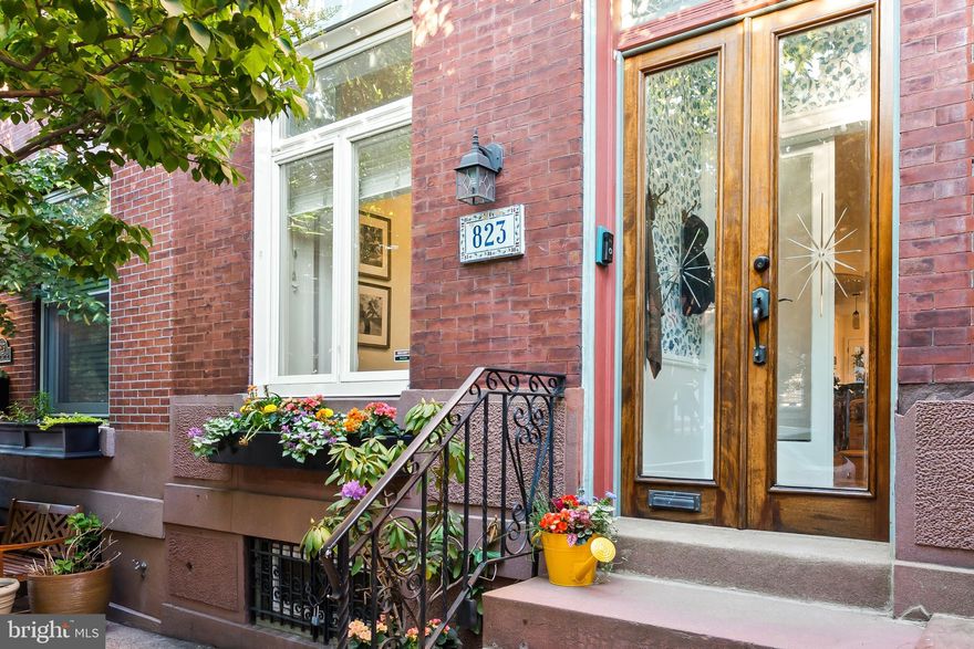 823 N. 25th Street — an elegantly reimagined 3-story, 4-bedroom residence perfectly positioned on a picturesque tree-lined block in the heart of the Art Museum Area. Thoughtfully and charmingly updated throughout, this exceptional home seamlessly blends timeless Philadelphia character with elevated modern finishes and sophisticated design.

From the moment you arrive, the home’s striking curb appeal and classic façade create an unforgettable first impression. Inside, a welcoming vestibule entry opens to a sun-drenched living room rich with architectural charm, featuring exposed brick, beautifully restored original oak floors with walnut inlay, crown molding, recessed lighting, and an oversized picture window that fills the space with natural light.

An elegant arched doorway leads into the spacious formal dining room — an inviting setting designed for intimate dinners and effortless entertaining. The stunning chef’s kitchen has been tastefully renovated with sleek white cabinetry, stainless steel appliances, quartz countertops, subway tile backsplash, breakfast bar seating, and a dramatic atrium-style window that adds warmth and character. Just beyond, the newly finished private rear patio offers the perfect urban outdoor retreat.

The second floor features three generously sized bedrooms filled with natural light, including a rear bedroom with bay window, an oversized center bedroom with convenient laundry area, and a spacious front bedroom. A beautifully renovated hall bath showcases designer tilework and refined finishes.

Occupying the entire third level, the private primary suite serves as a luxurious sanctuary complete with rich espresso hardwood flooring and a spa-inspired en-suite bath featuring a large glass-enclosed shower, decorative tile flooring, and an elegant vanity.

The finished lower level provides versatile additional living space ideal for a media room, lounge, gym, or playroom, along with an expansive storage area.

Perfectly situated just moments from Kelly Drive, Fairmount Avenue, public transportation, renowned restaurants, museums, and neighborhood favorites, this exceptional residence offers refined city living in one of Philadelphia’s most sought-after historic neighborhoods.