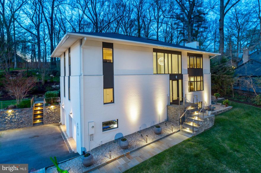 Conceived by Mark McInturff, FAIA, of McInturff Architects and rebuilt in 2015, this residence reads as both home and sculpture—4,265 square feet unfolding across three finished levels, offering 5 bedrooms and 6 full bathrooms and set with quiet precision on a professionally landscaped 0.48-acre lot in Chesterbrook Woods.  Materials are carefully composed: Porcelanosa surfaces lend a restrained, tactile continuity underfoot and throughout the baths, while Christiana kitchen cabinetry rises in clean, uninterrupted planes—concealed, architectural, deliberate. 

The entry is an experience in volume and light—a double-height hall where twin Moooi sphere chandeliers hover like installations, and Porcelanosa floors extend outward toward the landscape beyond. From here, the home reveals itself not all at once, but in curated moments: a living room wrapped in picture windows and softened by a gas fireplace; a dining space where light filters through expansive glass and sliding glass doors that extend the composition outward to the backyard terrace, where interior geometry dissolves into landscape. 

The kitchen is a lesson in composition—waterfall island, Caesarstone surfaces, and integrated Christiana cabinetry concealing function within form. Every element is intentional, from the Sub-Zero and Dacor appliances to the quiet efficiency of soft-close storage, allowing the architecture to remain uninterrupted. Beyond, the plan expands with quiet versatility: two bedrooms—one equally suited as a private office—alongside two full baths and a thoughtfully integrated laundry room, each space resolved with the same disciplined clarity.  

Upstairs, the private quarters continue the dialogue between light and structure. The primary suite rises beneath a vaulted ceiling, its geometry softened by natural light and calibrated illumination. The bath becomes a sanctuary of material and proportion—Porcelanosa tile, a sculptural soaking tub, frameless glass, and floating vanities arranged with gallery-like precision.  

The lower level extends the narrative—recreation with gas fireplace, fitness room, and utility area arranged with purpose and connected seamlessly to the 2-car garage and outdoor environment.  

Throughout, the home operates as a study in cohesion: hardwood floors refinished in 2026, integrated sound, sculptured lighting, and systems designed to support modern living without disrupting the architectural language. Outside, the landscape—azaleas, crape myrtles, stonework, and a flagstone terrace—acts as both frame and extension, reinforcing the dialogue between built form and natural setting.  

This is not simply a home, but a composition—where every line, material, and volume has been resolved with intention. 

Located within the Chesterbrook Elementary, Longfellow Middle, and McLean High School pyramid, the home is close by to neighborhood parks, shopping, swim and tennis clubs, trails, and major commuter routes, offering convenient access to downtown McLean, Tysons, and Washington, DC.