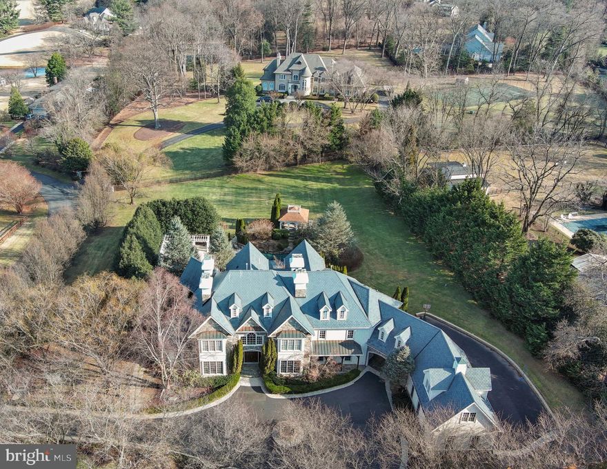 ***Luxury Living in Great Falls: A Grand Estate at 10447 New Ascot***Tucked away in one of Great Falls’ most prestigious enclaves, 10447 New Ascot offers an extraordinary opportunity to own a private, two-acre estate designed for both elegance and comfort. This 12,000-square-foot masterpiece seamlessly blends timeless sophistication with modern luxury, creating an unparalleled living experience just moments from the city.  A Grand Entrance to the estate welcomes you with a stunning foyer, where a grand curved staircase and coffered ceilings immediately set the tone for the home’s exquisite craftsmanship. Hardwood floors, intricate moldings, and multiple fireplaces add warmth and character throughout. Its refined interiors and thoughtful design offer both gracious entertainment and everyday luxury. The main level features embassy-sized formal living and dining rooms, perfect for hosting elegant gatherings. A spacious great room with a cozy, inviting ambiance. A sun-drenched library, offering a tranquil space for work or reading. A light-filled chef’s kitchen, equipped with commercial-grade Viking appliances, a butler’s pantry, a wine cellar, and ample space for casual dining. A sunroom and a private bedroom suite, providing flexibility and comfort. The upper level is home to four generously sized bedrooms, each with its own private en-suite bath. The primary suite is a true sanctuary, featuring a sitting area with a dual-sided fireplace, a wet bar and coffee station for ultimate convenience, a spa-like bath, complete with a soaking tub, oversized shower, and premium finishes. There is a private fitness area and access to a large office or retreat space above the garage, with its own private staircase leading directly to the garage. The Lower Level is an entertainer’s dream, designed for relaxation and entertainment, offering a sunken bar and recreation room, a media room and gaming area, a full bath, additional bedroom, and wine cellar. A stunning sitting area overlooking a breathtaking sunken patio with a cascading waterfall feature. Step outside to experience this resort-style, outdoor luxury living with lavish landscaping and a paver circular driveway rear load garage, fenced-in backyard, and expansive patio, perfect for outdoor gatherings, a sparkling pool and spa, all provide the ultimate relaxation and entertainment space. This home has been meticulously maintained and is move-in ready.  You can tell that it has been lovingly cared for by its current owner. This exceptional estate is ready for its next chapter. Whether you’re seeking a private retreat, an entertainer’s dream home, or a sophisticated family residence, 10447 New Ascot offers unmatched elegance and comfort in the heart of Great Falls. Schedule a private tour today and experience this one-of-a-kind estate firsthand!