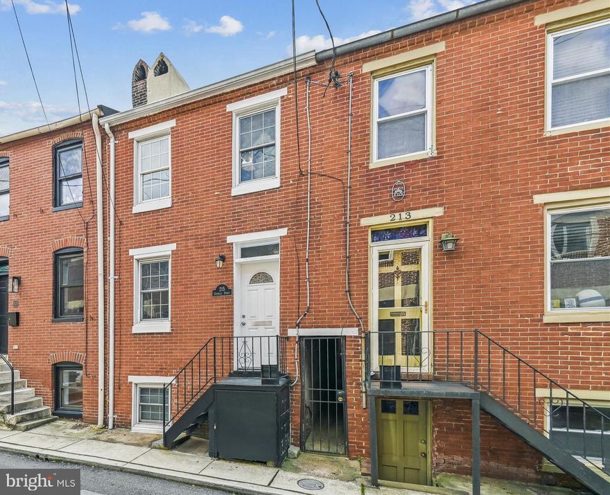 Convenient living at its best in this 2 bedroom, 2 bathroom townhouse located in The Federal Hill District.  Walking distance to Cross Street Market.  The home has been updated over the past years.  Open floor plan on the main level with newer flooring and a modern kitchen with granite countertops, stainless appliances, and recessed lighting.   The living room has a cozy brick wood burning fireplace.  The upper level consists of the primary suite with  another wood burning fireplace, bathroom, and a private balcony overlooking the serene backyard.  The primary suite can be converted into two bedrooms as well.   Enjoy movie night in the lower level  family room with  another wood burning fire place and second bathroom.  Cozy fenced-in backyard with a patio.  The roof was updated  in 2018, A/C 2018, kitchen 2018, windows and exterior doors replaced approximately 10 years ago.  Great location and perfectly priced!  Home is Sold "As Is"