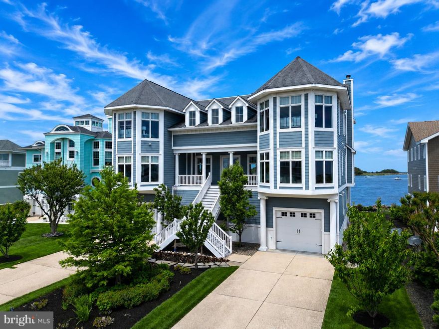 This impressive bayfront residence offers the ultimate coastal lifestyle, ideally situated on the south side of the Indian River Inlet within the prestigious gated community of South Shore Marina, surrounded by the protected beauty of Delaware Seashore State Park. Located just five miles from both Bethany Beach and Rehoboth Beach, this expansive 12,000 sq ft home offers wide open water views from every room and an unmatched setting for luxury waterfront living. Designed for exceptional entertaining and hosting friends and family, the home welcomes you with a grand foyer leading into an impressive great room anchored by a wood-burning fireplace and soaring ceilings. A dramatic 28-foot wall-to-wall accordion door seamlessly opens to an expansive waterfront deck and screened porch, creating a true indoor-outdoor living experience with panoramic inlet views. The gourmet chef’s kitchen is beautifully appointed with custom wood cabinetry, granite countertops, Wolf energy-efficient appliances, Sub-Zero refrigeration, an oversized center island with prep sink and seating, a walk-in pantry, and a dedicated bar area. A stunning crescent-shaped bar with seating for ten and built-in beverage coolers further enhances the home’s entertaining appeal. The main level also features a private guest suite and an office/bedroom.  Throughout the home,  20 built in indoor speakers controlled by a Sonos system creates the perfect atmosphere for gatherings both large and small. A sweeping staircase leads to the second level, where five spacious bedrooms await. The main primary bedroom includes an exceptional waterfront primary suite with a private balcony overlooking the bay, spa-inspired bath, and generous walk-in closets. Additional guest accommodations include a Jack-and-Jill suite, a bedroom with private bath, and a second primary waterfront suite with private bath access, creating ideal accommodations for family and guests. The third level offers a spectacular recreation room complete with television lounge, pool table, shuffleboard, half bath, and breathtaking panoramic water views, with access to elevated observation decks that capture both sunrise over the Atlantic and sunset over the bay. It is legitimately one of the best views in Bethany Beach with exceptional vantage points.  The lower level is equally impressive, featuring a fully equipped fitness room, multiple utility areas, tankless water heaters, extensive garage space, and more than 1,500 square feet of temperature-controlled storage. Dual laundry areas provide added convenience for large households with a laundry room on the lower and bedroom level floors. Outdoor living is elevated with over 3,500 square feet of decking and outstanding fishing directly from your backyard. Whether hosting large gatherings or enjoying quiet mornings on the water, the outdoor spaces are designed to take full advantage of this extraordinary setting. Additional luxury features include an elevator servicing all levels (except the attic recreation room) and exceptional commercial-grade construction with a steel I-beam structural framework, cast-iron fire sprinkler system, 72 pilings, and 88 yards of concrete, with the home built notably higher than many neighboring properties. Residents of South Shore Marina enjoy access to a deep-water marina, swimming pool, tennis courts, and clubhouse. Spend the day boating with direct access to the Indian River Inlet and the Atlantic Ocean, walk or bike to the guarded state park beach without ever crossing Route One, or enjoy waterfront dining and entertainment just moments away at the Big Chill Beach Club.