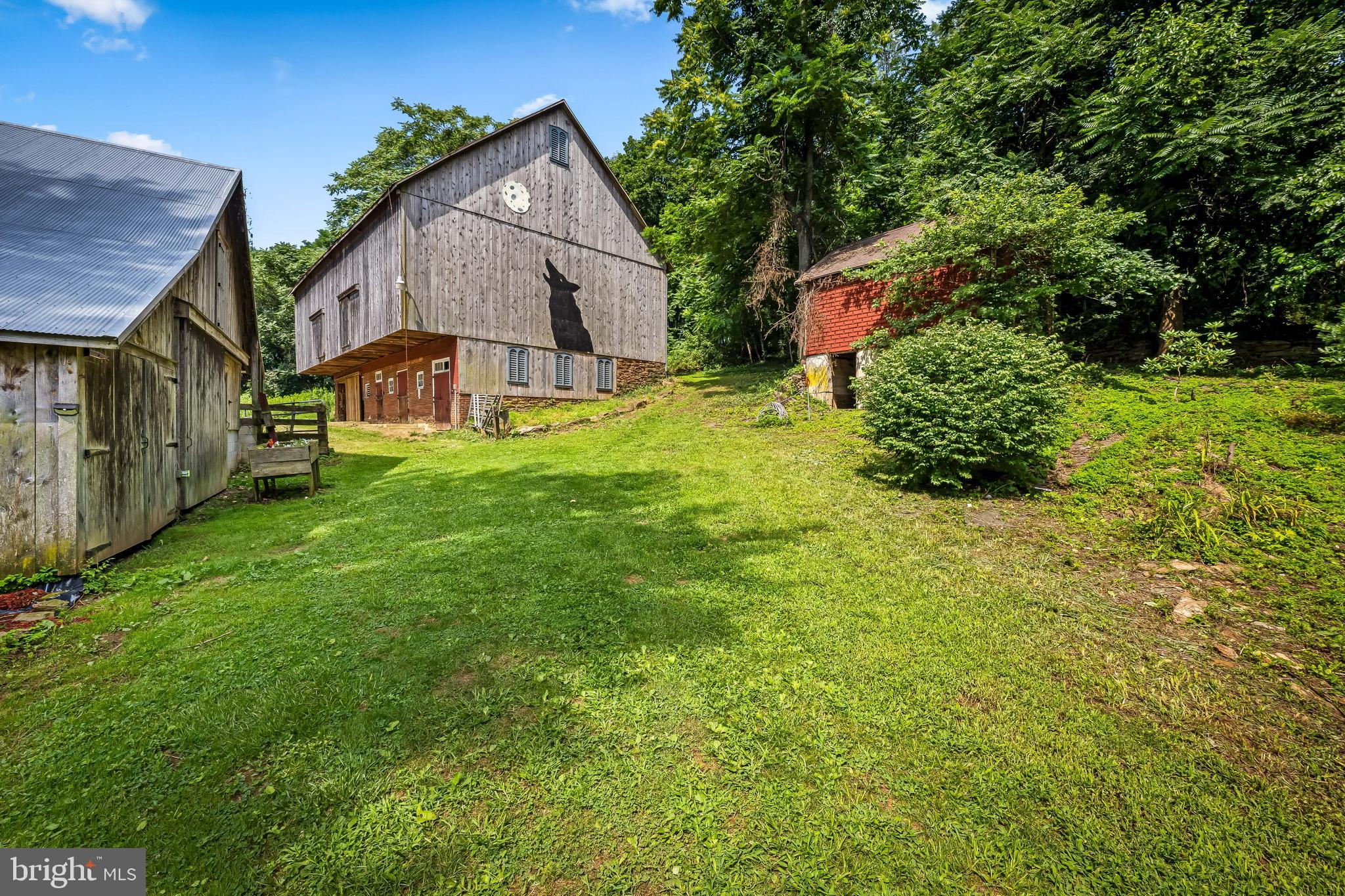 Who doesn't want to live at Laughing Wolf Farm? So charming, with a three bedroom farmhouse with two full baths, and more outbuildings than can imagine. There's a summer kitchen, a barn with stalls for horses, Alpaca, and more, a spring house that makes a great art studio, and a smoke house. Don't miss the root cellar. Oh, and barns--there are three! A bank barn with the stalls, a three-bay barn with chicken coops or rabbit hutches (or previous owner kept pigs), and another barn for storage. Multiple options come to mind with this charming farmette just seconds to Main St Shrewsbury and easy commute to Maryland or York on I83. Any and and all amenities are tucked away in behind this traditional two story home, with sprawling outbuildings, a gorgeous bank barn with metal roof embraced by a stone foundation features large stalls, a small tack room below and a huge area above. The barn was re-sided with 1'1/2" hemlock in 2011 and the metal was repainted and sealed at that time. The barn also has water and electric. The field(pasture) or (football/lacrosse/soccer field) adjacent is totally fenced with gate and will welcome any kind of passion you can think of. If you prefer a cooler and tranquil form of play then take a stroll through the walking/riding/ path thru-out the approx 1.5 acres of wooded area behind the barn with connecting paths with special little openings for a quiet get-a-way, firepit, and/or picnic! Enjoy the historic nature of this property with a working brick summer house with FP and loft, a root cellar with a CIP arched ceiling tucked into the hillside, spring house with running spring, smokehouse with origianl hooks. An additional three bay(could be garage) was also re-sided in 2011, with above storage and a mansion of a chicken coop along the side. Property also features multi-flora rose, daffodils, crocuses, bluebells, Lillies, bee balm and Raseberry, blueberry, blackberry and wineberry bushes.
The home is beyond charming and interesting with a first floor primary suite with the most detailed primary bath which is a reproduction of time gone by, Stain glass pocket door, beautiful tile floor and knee walls with stand alone shower and tub plus vanity area to pamper yourself(fully handi-caped accessible). Rustic charm is the way to describe the kitchen with a working fireplace, several built-in pantries and walk-in closet/pantry as well. Large sink with greenhouse window for all your flowers plus ample table space. Mud room behind the kitchen with w/d, furnace and space to hang your hat. Two staircases to the upper level, one from the kitchen area and the other from the foyer off the covered front porch. Two very large bedroom plus a bonus room with bath.
Welcome to your new happy place! There is no flood insurance required. Some third party sites have an error.