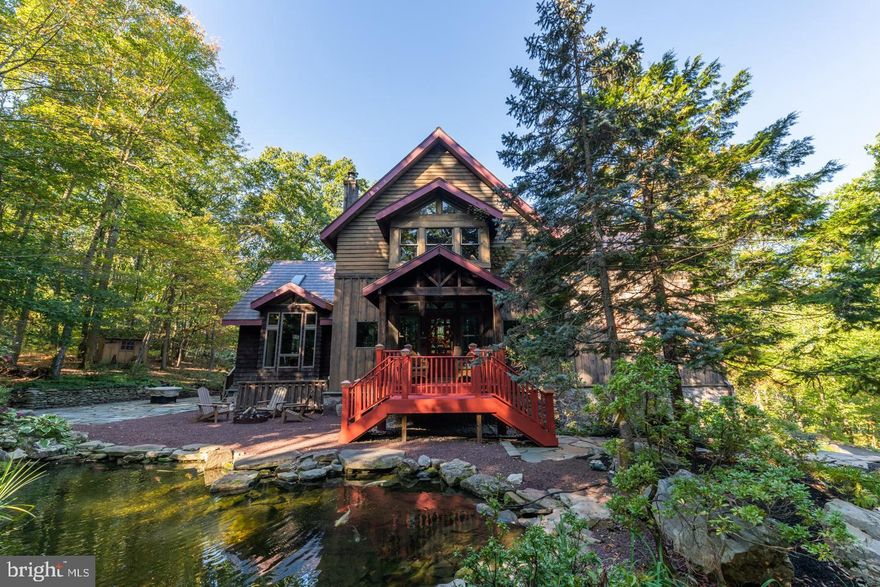 Have you been searching for a singular property which includes a beautiful home of artisan craftsmanship, out of the sight of any neighbors, but within a ten minute drive to Doylestown, New Hope and a stone’s throw from Peddler’s Village? And you want all of this on a gorgeous lot with no sound except a babbling water feature with a koi filled pond and the wind whispering in the trees? Welcome to Fox Hollow, an impeccably built post and beam home on just over 4 acres of stillness and serenity. Mountain Top Road is just that; a winding country road up Buckingham Mountain, which is one of the most beautiful and romantic hills in the county, dotted with boulders of all sizes worn smooth by the ages and which are known as the “wolf rocks”. A long paved driveway leads past the carriage house to the main home; a simply beautiful cedar sided three story home with a covered porch and a two story glass “prow”  which allows for gorgeous views. Imagine coffee on the porch watching the sunrise and evenings on one of the three back decks with a glass of wine. Enter through the foyer into a stunning two story great room with the prow forming walls of glass flanked by additional picture windows and glass doors to the two decks. Even though this room is large enough to serve as a full living and dining space, small touches such a reading nook with floor to ceiling bookcases and a gas fireplace keep it cozy and warm not to mention the radiant heat! The kitchen is to the left with an oversized island in the center and extensive cabinetry surrounding. A six burner wolf range, subzero refrigerator and multiple prep areas make cooking a pleasure. The exposed beams, large windows and combination of natural materials make this room the heart of the home. A back door leads out to the large paver patio. Two spacious bedrooms are also on this floor and share a full bath. In addition there is a half bath. The second floor is one fabulous large master suite. The suite is open to the main floor and shares that fabulous sunset view out the prow. It feels like you are sleeping in the treetops. The bedroom itself is quite a spacious room, with an amazing, handcrafted bookcase system which acts as a privacy wall from the main floor. The master bath is lovely with a slipper tub and separate large stall shower. In between the master bedroom and bath are two big walk in closets and a double sized linen closet as well as a laundry room and balcony overlook sitting area. On the lower level you’ll find another bedroom and full bath. There is also a family room, separate office and a billiards room with wet bar! The lower level has its own separate entrance off of the driveway. Now to the carriage house with second floor bi-level guest apartment with full kitchen and bath! New wood floors are an attractive addition to the apartment which is over the garage and storage rooms. Heated and air conditioned it consists of a 20x23' great room and full 12x11' kitchen and full bath 'on one level and a spiral staircase up to the sleeping loft above. On the ground floor is a separate 13x11' room good for exercise or office and it also has washer/dryer hookups. This could make a terrific workroom as it’s just off of the garage. The garage currently has one car space with the rest used for storage but there are three garage bay doors and the possibility to convert back to a three car garage. Upgrades include new metal roof on home and carriage house, complete renovation of the apartment and much more. Equidistant from NYC and Philadelphia, in roughly 90 minutes, just over the bridge from Princeton and a comfortable drive from 4 airports, this amazing home is built with one of a kind construction that brings fun and joy as you live within. All in Blue Ribbon Central Bucks School District!