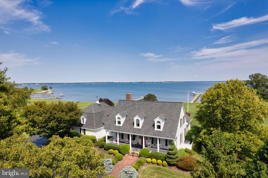 This superb custom Southern Living plan boasts impressive deep, intricate trim and multiple custom windows/transoms and is designed to take advantage of the expansive water views.  The two-sided soaring brick fireplace can be used as a gas or a woodburning unit.  A volume 2-story Great Room offers a wet bar for easy entertaining and access to a sizable deck along with extraordinary panoramic water views for miles! The sumptuous Gourmand Kitchen houses a commercial-style gas stove and a vast center island.  The Breakfast Nook overlooks a sparkling 20X40 heated Inground Pool, generous stone patios and an absolutely breathtaking and truly exceptional Gazebo built with an outdoor kitchen that includes a grill, burners, a sink and multiple appliances, combined with a large mounted TV and plentiful seating for the ultimate outdoor living experience!  A fourth wonderful full bath is found just off the garage and an outdoor pool shower is also provided for your boating and swimming enthusiasts.  The well-lit 300 ft private pier houses a lift for your power boat plus additional space for a smaller watercraft to emphasize what a true waterfront lifestyle can offer.  You will find a very generous main level Primary Suite featuring abundant closest space, a luxury bath and access to the deck in this gracious waterfront residence.  A second rear staircase off the first floor Laundry and Pantry takes you to an additional lovely large Family Room and Office space which adjoin three Guest Bedrooms and two additional baths.  Prepare to serve and entertain family and friends in the Formal Living Room and Romantic Formal Dining Room.  Perhaps you will want to idle away the hours on the extensive front porch in the Southern Living style as you watch the sun set or bring that coffee cup out to your deck or Gazebo to see mesmerizing sunrises and your wine glass or drink out to face East to see memorable horizons where the moon comes majestically up to meet you.  Community amenities include a Clubhouse, waterfront walking trails, Tennis Court, Boat Ramp and a small Playground.  Lots of community events are held there if you want to join! Owner unsure of water frontage...believed to be wider that 210 ft. shown.