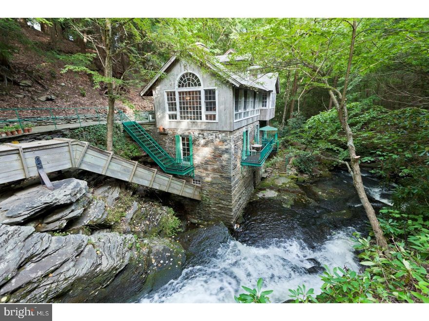 A once in a lifetime offering in a unique and breathtaking setting, words can hardly describe the serene beauty found on this ultimate family compound located just ninety minutes from Manhattan in bucolic Mill Rift, PA. On sixteen private acres, the Bushkill River winds its way through the property, flowing into three spectacular crystal clear waterfalls that then form natural pools for swimming below. Strategically placed lights illuminate majestic mount laurels and pines creating a wonderland at night while inviting tiered blue stone patios along both sides of the falls are connected by several foot bridges allowing for hours of relaxation and exploration. Three houses all unique in size and character have been lovingly restored with details ls plucked from Tuscany and include a sunny three bedroom Victorian, a guest house with wraparound deck, greenhouse, modern and complete kitchen with granite counters, brass sink and stainless steel appliances, three bedrooms and the historic stone saw mill. Restored in a labor of love by current owners, this home needs to be seen to be believed. Built alongside the falls, every room is enveloped by the sights and sounds of the cascading waters. The living room with its walls of windows allows visitors to take in the spectacular scale of the environment. A true chef's kitchen includes a cooking fireplace, professional grade appliances. Doors to balconies offer the view of native trout waiting to be fished and the mist of the water as it moves through the property. Throughout all three houses bathrooms have been remodeled with every luxury in mind. Adding to a heavenly package are an art studio, handsome private home office, two garages, a barn with water and electric, fenced vegetable garden and a deluxe log sauna. See also MLS: 6656071.