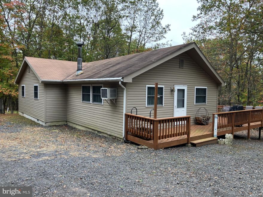 Move right in - 4 bedrooms, 2 baths, wood stove wrap-around deck 1 acre corner lot in STR-friendly amenity-filled and gated community