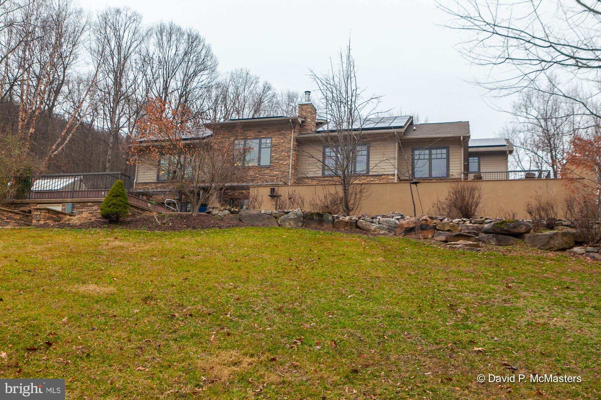 Exceptional. Extraordinary. Intriguing. Unique. Great Value. Private. Unrestricted. Beautiful views. High Quality Construction. 16 + acres. Endless pool. Pond. 5 Bedrooms, 4 full baths. Separate guest/MIL quarters upstairs with full kitchen and laundry. Gourmet Kitchen w/dual quartz islands and sinks, 7000 + Sq. ft. Wood floors. Extensive built -ins. Beautifully crafted doors and woodwork throughout. Ceramic tile floors and baths. Amazing sauna. Pool table convey. Extensive decks, walled patio and outdoor fireplace. European soapstone fireplace. Outdoor grill and kitchen. Stone walls and walkways. Mt Views. Outstanding landscaping and gardens. 3 Laundry Rooms. Low Utility Bills. Solar Panels + Geothermal HVAC if you want to unplug and/or save money. Additional workshop building. Greenhouse. Conceived with an eye to the environment. Built for entertaining friends in a peaceful, naturally beautiful setting. Built for a workplace away. Built to enjoy and cultivate nature. Plantings and flowers abound. Convenient. Minutes to I-81 and the Marc Commuter train to DC. Built by a couple who could afford the best and had an unlimited budget. Edward Burns, an award winning American producer, screenwriter and novelist; best known for his collaboration on "The Corner" and The Wire (HBO). and his wife Anna created a joyful, beautifully considered and executed home. Built in 2007 by Cedar Creek Builders ( Jamie Yates). This custom built sanctuary is built of Stone and hardiplank. There is a luxurious master suite with solid cherry built-ins. The present owners have continued to provide great care and consideration in maintenance and adding additional features. See the careful attention to detail provided in the Document Section comments from the present owners, "Welcome to Our Home", and also a listing of what they have added and provided for the property during their ownership. THIS LARGE HOME WAS REALLY BUILT TO ENCOURAGE OUTDOOR LIVING + A HEALTHY LIFESTYLE. IT WOULD MAKE A GREAT B&B or AIRBNB. Misc other features; geothermal heating and cooling radiant hot water floor heating, solar and propane instant hot water heaters. Solar electric system stores 3 days of electric power. There is also a new backup propane generator that ensures the solar batteries remain charged. This means you have power to the house indefinitely should an outage occur. With the spacious 4 car attached garage with wood doors your mountain property is complete.