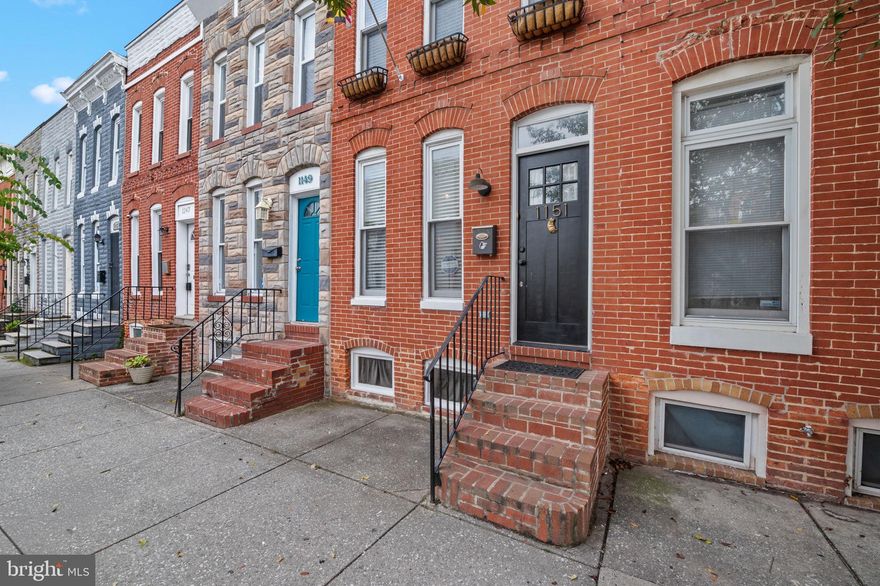 Welcome to 1151 W Cross Street, a bright and beautifully updated federal-style rowhome in Pigtown. With 1,272 square feet of finished space spread over three levels, the home features two large bedrooms upstairs, 1.5 bathrooms, and a finished basement that’s perfect for use as a home office or additional living space. Gleaming hardwood floors, exposed brick walls, and abundant natural light add warmth and character throughout.
The main level offers an open and inviting layout with a spacious living and dining room, and kitchen that combines style and function with ample cabinetry, prep space and easy access to the backyard. Step outside to the fenced backyard, ideal for entertaining or simply enjoying the outdoors. Upstairs, the bedrooms are generous in size and filled with natural light, while the finished lower level provides great flexibility for guests, a workout area, or media room.
Pigtown is known for its vibrant sense of community, where neighbors come together for local events, block parties, and the annual Pigtown Festival. Just minutes from Camden Yards and M&T Bank Stadium, it’s the perfect spot for sports fans and city explorers alike. You’ll also find yourself surrounded by some of Baltimore’s best breweries, neighborhood hangouts, and dining options. Exciting growth is underway with the Warner Street Entertainment District, soon to feature The Walk at Warner Street and The Paramount, the city’s newest concert venue. With so much happening right outside your door, this is a neighborhood that offers both connection and convenience—making this home a rare opportunity to enjoy timeless charm in one of Baltimore’s most dynamic locations.