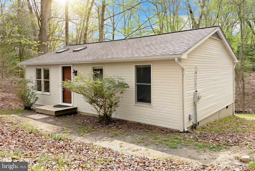 Welcome to 1111 San Angelo Drive! A private retreat tucked away at the end of a quiet dead-end street in beautiful Chesapeake Ranch Estates in Lusby. This 2 Bedroom, 1 Bathroom home offers the perfect blend of nature, comfort, and community living. Surrounded by trees and serenity, you’ll love the rare privacy and water views, while still enjoying all the incredible amenities Chesapeake Ranch Estates has to offer,  including private lake access, sandy beaches along the Chesapeake Bay, playgrounds, athletic fields, community gardens, and miles of scenic hiking trails. Step outside and you’re instantly connected to nature, with trails leading directly to Parker Moore Creek, perfect for peaceful walks, exploring, or simply unwinding after a long day. Inside, thoughtful updates make this home move-in ready including a NEW ROOF, beautiful hardwood floors, and recently updated 3-season room, Ideal for morning coffee, evening relaxation, or entertaining while taking in the wooded surroundings.  The combination of natural light and warm finishes creates a welcoming, comfortable feel throughout. Parking is a breeze with both driveway and ample street parking, a rare bonus in such a tucked-away setting. If you’ve been looking for privacy, outdoor adventure, and community amenities all in one, this is it! Info from Chesapeake Ranch Estates: "67 miles of privately owned and maintained roads; 2 private sandy beaches on the Chesapeake Bay; a large man-made freshwater lake for swimming, fishing and sailing; a private airpark with 28 surrounding homes having adjoining aircraft hangars, a paved and lighted 2550-foot runway; a wooded campground; horseshoe pits; hiking trails; a field of private garden plots; and an athletic field. CRE has an exclusive roving Security Force, in addition to a Roads Department that maintains the 67-mile of roadway throughout the year, including snow removal."