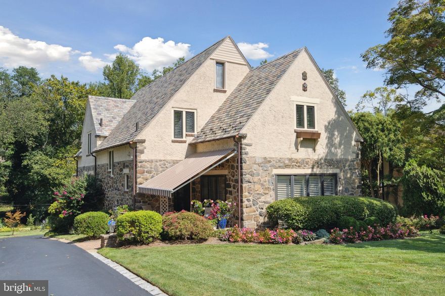 Welcome to 1229 Grenox Road, a beautifully updated and meticulously maintained stone tudor nestled on a serene, tree-lined street in Wynnewood. This home offers the perfect blend of classic elegance and modern comfort. The slate roof adds to the beauty and  charm of this home. Situated on over a half an acre, this homes provides outdoor space for relaxation, play and gardening. It is a true oasis in the heart of Wynnewood. With 4 bedrooms and 3.5 baths, this home is thoughtfully designed for comfortable family living and hosting guests. As you enter this home you are greeted by a beautiful Entry Hall  which includes a large coat closet and a newer Powder Room. The Living Room exudes warmth and character and has a stunning, stone fireplace. French doors lead you into the bright and sun-filled Sunroom. Adorned with plantation shutters and original stonework it is a tranquil retreat. A newer split system ensures year round comfort, making it an inviting space for all seasons. The elegant Dining Room with newer French Doors enhance the ambiance and create a seamless flow for hosting large dinner parties or intimate gatherings. From the Dining Room step into the kitchen with newer tile and granite countertops. Adjacent to this room there is a spacious Pantry Room . It has additional cabinets, countertops and a sink , making it an ideal spot for meal preparation, storage and organization.The Breakfast Room bathes in natural light and is perfect for casual family meals or enjoying your morning coffee. For added convenience , a full Laundry Room includes a sink and a closet which provides  additional storage. To complete the first floor, there is a separate room designed for entertaining. Featuring a wet bar, cabinets and glassware storage-this is a perfect space for hosting parties and gatherings- for mixing cocktails and creating memorable moments with friends and family.
As you go to the second floor you see the striking original staircase- a symbol of the home's character and craftmanship. At the top of the stairs you will find a sizeable landing that sets the tone of the second floor. The Primary Bedroom is large and spacious . Adding to this there is a separate Dressing Room with additional closet space. The newer Primary Bathroom includes a separate bath and shower . Storage space is added so that there is room for everything you need. There are three additional Bedrooms. These rooms offer versatility for family members, guests or creative use of space to suit your needs. The hall Bathroom has been updated while retaining some of the original tile. A large Hall Linen Closet is there for easy storage of linens and essentials. For those seeking additional storage or potential for expansion, there is access to a walk-up floored attic.
The centerpiece of the basement is the above ground Family Room. With its beamed ceiling, inviting stone fireplace it exudes warmth and charm. The Carousel Horse Wet Bar adds a whimsical touch, a perfect setting for entertaining or spending time with the family. An outside Entrance leads to a redone flagstone patio with an awning, inviting you to enjoy the beautiful plantings and grounds. The addition of a Full Bathroom on this floor adds both convenience and functionality.In addition there is a large Storage Room plus a Plant Room- equipped with a sink and additional storage- it is a perfect space for those who are serious gardeners or who want to just putter in the garden.
Additional features - hardwood floors throughout. heated 1 and a half car garage,7 zone sprinkler  system, whole house generator,front patio with pavers and lights, driveway sealed and lined with Belgium Block and chimney repointed and sealed.
A truly beautiful home  which has received much love and care-its  prime location offers proximity to shopping, dining, award winning Lower Merion Schools, transportation,  and libraries.
