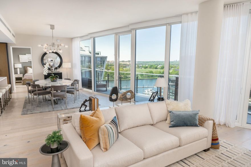 Welcome to the pinnacle of waterfront luxury at Amaris, an architectural statement by Rafael Viñoly and the crown jewel of The Wharf. This striking penthouse offers two bedrooms, a den, and two and a half baths — wrapped in elevated design and rarefied views. The open-concept living and dining areas are framed by floor-to-ceiling windows, automated shades, and wide-plank French oak hardwood floors, creating a seamless flow of light and air. A private terrace spans the full length of the residence, offering dramatic panoramas of the Potomac River, The Wharf, East Potomac Park, and beyond — a breathtaking backdrop for everyday living and elegant entertaining. The adjacent chef’s kitchen is equipped with Stevali Italian cabinetry, marble countertops, and top-of-the-line appliances, blending beauty and functionality for everything from weeknight dinners to curated events. The gracious primary suite features terrace access, ample custom closet space, and a spa-inspired bathroom designed for restoration. Both bedrooms enjoy floor-to-ceiling windows, flooding each space with light and river views. A versatile den completes the layout, ideal for a home office or media lounge. Additional highlights include two garage parking spaces with EV charging, an oversized private storage unit, and access to Amaris' world-class amenities: 24-hour concierge, valet service, indoor lap pool and jacuzzi, and a two-level fitness center outfitted with Peloton equipment. Outside your door, The Wharf delivers an unmatched lifestyle — with celebrated restaurants like Del Mar, Moon Rabbit, Officina, and more just steps away. This penthouse isn’t just a place to live — it’s a statement of arrival.