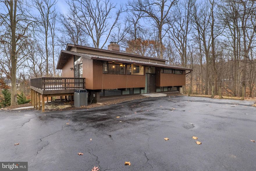 Discover the perfect blend of timeless mid-century modern design and thoughtful contemporary updates at 3230 Basford Rd. Nestled on 1.5 private, wooded acres just minutes from historic downtown Frederick, this original-owner, custom-built contemporary home offers unmatched craftsmanship, character, and comfort.

Step inside to an inviting open floor plan highlighted by vaulted solid-wood ceilings, exposed beams, and expansive windows that fill the home with natural light. The central living area features two stunning fireplaces, including a striking stone-mantled centerpiece that anchors the space with warmth and style.

The home has been beautifully renovated, including a brand-new custom kitchen appointed with premium cabinetry, sleek countertops, and high-end stainless steel appliances—a true showpiece for cooking and entertaining. New flooring extends throughout the home, adding a cohesive and modern finish. The lower level includes ductless mini-splits in the basement bedrooms, ensuring year-round comfort and efficiency.

Enjoy exceptional indoor-outdoor living with a spacious wraparound deck offering serene wooded views and privacy—perfect for morning coffee, evening wine, or gatherings with friends and family. The fully finished walkout basement, featuring a full wall of windows, opens to a generously sized patio tucked beneath the deck, creating an additional peaceful outdoor retreat.

A rare offering in Frederick County, this home pairs unique architectural character with thoughtful upgrades and unbeatable proximity to the restaurants, shops, trails, and amenities of downtown Frederick. Whether you’re drawn to its design, its setting, or its convenience, 3230 Basford Rd delivers a lifestyle that feels both secluded and connected—modern living wrapped in natural beauty.