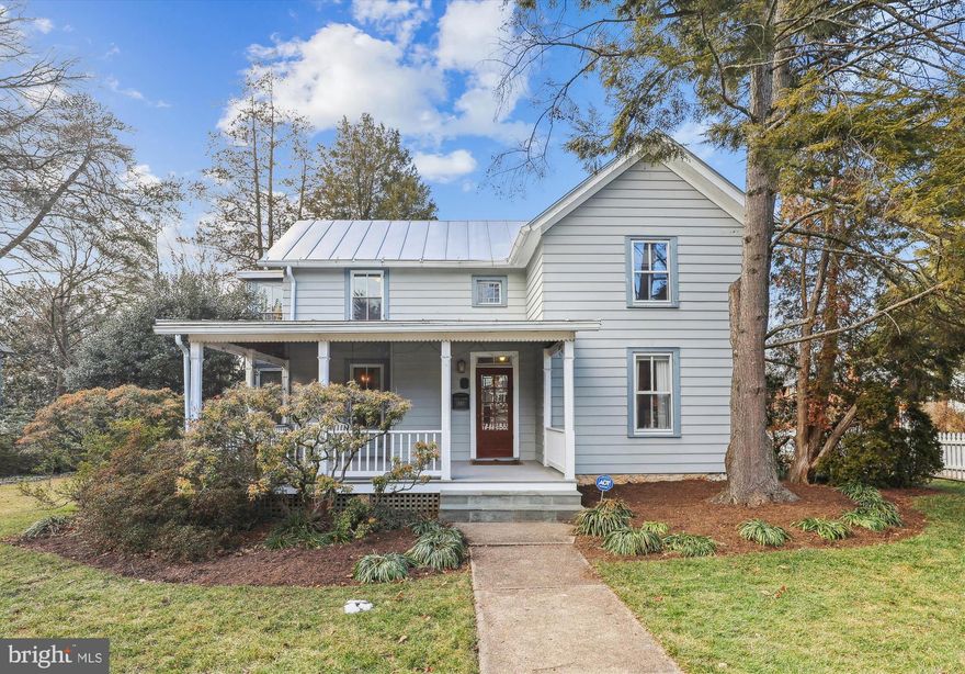 Step into timeless elegance with this beautifully maintained and updated 4 BR/2 BA historic farmhouse, built in 1896 and nestled in the heart of Falls Church City. Set back on a picturesque lot, this home showcases exquisite architectural craftsmanship while seamlessly incorporating modern updates for today’s lifestyle.  Inside, you’ll find a thoughtfully renovated kitchen featuring quartz countertops, high-end stainless-steel appliances, a breakfast bar, and a sunlit breakfast room with a pantry and closet. The main level boasts warm pine wood flooring, a formal dining room, and a spacious living room with a wood-burning fireplace—perfect for gathering with family and friends. A versatile bedroom/den with an adjacent laundry room adds convenience and flexibility to the first floor.  Upstairs, the home offers three generously sized bedrooms and a dedicated office/den space. The additional primary suite is a true retreat, complete with two closets, a private sitting area, and an en-suite bath featuring the original clawfoot tub. Additional charming details include a wall to wall built-in bookcase with desk in the upper-level front bedroom, marble flooring in both bathrooms, custom radiator screens, a built-in cherry bookcase in the den upstairs, and ample closet space throughout.  Outside, enjoy a welcoming front porch, a lush yard with beautiful flowering plants, and a detached two-car garage with a workshop and upstairs loft area. Ideally located just moments from downtown Falls Church City, this home offers easy access to local shops, dining, trails, and major commuter routes.  A rare gem in sought-after Falls Church City, this home perfectly blends historic character with modern comforts—all within the highly acclaimed Falls Church City school district.