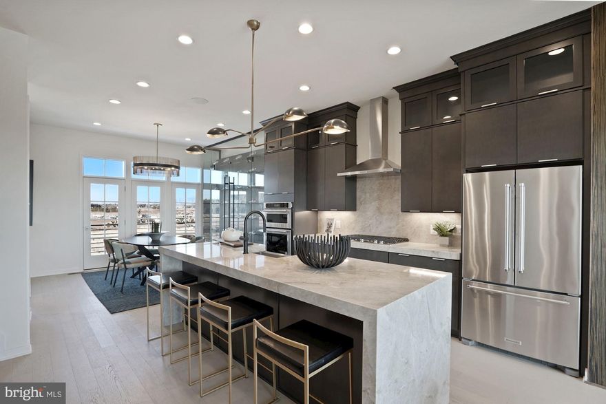 Metro Walk - The Towns! This Foggy Bottom offers 4 bedrooms, 3 full baths, and 2 half baths; designer curated upgrades enhance the beauty of this light filled home. A private first floor bedroom with an en suite is perfect for guests! The gorgeous kitchen, open to the great room and dining room, boasts 2-toned cabinets and upgraded quartz countertops. The great room features 12’ stacking doors which lead to a large covered balcony. The fourth-floor loft offers a wet bar, perfect for entertaining. Enjoy sunsets on your rooftop terrace with beautiful views overlooking a tree preserve area. Metro Walk’s convenient location is a quick walk to the Ashburn Metro Station and future retail developments!  Future amenities include a clubhouse w/ a fitness center and yoga studio, outdoor pool, playground, and an outdoor movie screen. Walking trails wrap around and throughout the community.