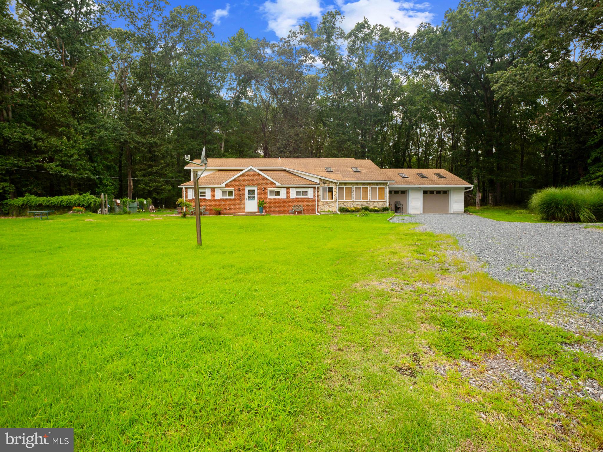 Just minutes from Franklin State Park, the West River, and the Chesapeake Bay, this 4-bedroom, 2-bath Churchton home captures the essence of relaxed coastal living. Whether you're drawn to peaceful waters, community piers, bayside dining, or quaint local shops, this location offers it all. Step inside to a spacious main level with warm wood flooring and architectural columns that subtly define the space, creating an elegant area for a formal sitting room or dining room. Just off the entry, a flexible bonus room with its own closet offers endless possibilities—home office, play space, or creative studio, whatever your heart desires.
The bright galley kitchen feels like a Tuscan escape, with crisp white cabinetry, butcher block counters, floating shelves, and a painted white brick accent wall that adds charm and texture. Tile floors provide a special touch, while natural light enhances the inviting ambiance. Just beyond, you’ll find a main-level bedroom and full bath, along with a convenient laundry area. On the other side of the home, a den, second bedroom, and formal dining room offer even more living space, while the family room—with vaulted ceilings, skylights, and French doors—creates a warm and welcoming gathering spot before heading upstairs. The upper level features a lofty third bedroom and a full bath, while the generous primary suite overlooks the backyard and includes two sizable closets—offering comfort and privacy. Outside, mature trees frame the backyard with natural beauty, and an attached two-car garage adds both practicality and storage.