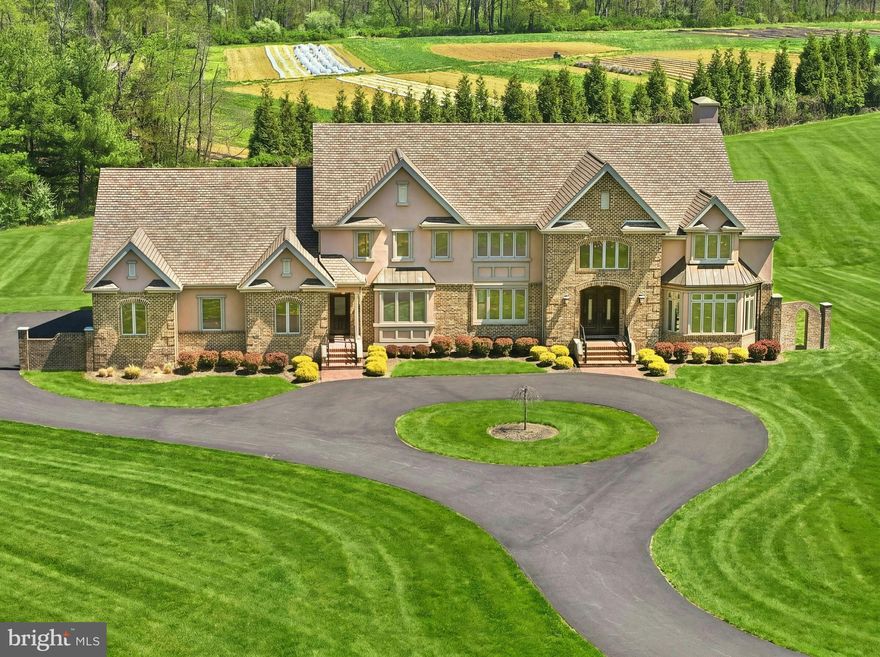 Broadmoor, an exceptional Estate set on over 6 beautiful acres in iconic Bucks County. Broadmoor pairs privacy with prestige in the premier township of Solebury. A sweeping circular driveway creates a grand approach to the Main Entrance. A Secondary Entrance streamlines daily access to living spaces and a Private Office. Ideal for work-from-home, deliveries and catered events. Move-in ready, this home looks brand new. Expansive windows brighten each room with natural light, while flexible spaces adapt to your lifestyle. A Private Elevator connects all levels, bringing comfort and convenience to daily life and multi-generational living. The Private Office, with a double-door entry and scenic window seat, inspires focused work, creativity and quiet escape. Comfort meets energy-efficiency with 8-zones of eco-conscious Geothermal heating and cooling, a rare luxury. A standout feature, 2 Primary Suites with spa-inspired Baths featuring double vanities, integrated beauty zones, soaking tubs, showers, tray ceilings and heated floors. Suite One stuns with a double-door entry, double-sided fireplace with onyx hearth, sitting area, 2 walk-in closets, glass doors and tray ceilings. Suite Two impresses with elegant columns framing a sitting room and dual double-door entries, one to the bath and one to a spacious walk-in closet. Perfect for guests or multi-gen living. Two additional roomy Bedrooms, each with a walk-in closet, share a large full Bath with heated floors. A boutique hotel-style hallway reveals a rare gem, an expansive unfinished Private Wing near the Elevator and Secondary Staircase. Ideal for a gym, yoga retreat, art studio, 5th bedroom or in-law/au pair suite. On the 1st Floor, the Grand Foyer dazzles with a floating staircase, graceful arches and sweeping balconies. Walls of windows fill the Living Room with panoramic seasonal views, while stately columns define a Dining Room ready to impress. An adjacent Butler’s Pantry keeps events stress-free. Soothing, nature-inspired tones of the Gourmet Kitchen wrap you in the comforting warmth of home. From busy mornings to weekend gatherings, the expansive island, with prep sink and seating, invites connection and conversation. Abundant cabinetry, walk-in pantry and custom workstation simplify daily living. A sculptural Planter with polished river rock stones and columns adds artistic flair. Casual dining shines in the Breakfast Room with panoramic views by day and moonlit skies by night. For cozy evenings and relaxed gatherings, the Great Room sets the mood with a floor-to-ceiling fireplace, an oversized hearth built for seating, French doors, archways and warm cabinetry. Double sliding glass doors open to a Covered Terrace with skylights above. Unwind, savor meals and host with ease amid grand columns, custom balusters and a private backyard oasis. Quality conveniences include 2 Powder Rooms, a spacious Laundry, statement lighting, a chandelier lift, quartz countertops, soft-close wood cabinetry and a wealth of closets with customizable storage to keep life comfortably organized. The massive 3+ car Garage, perfect for car or garden enthusiasts, has soaring ceilings, natural light, a double sink, storage closet and a private entrance. The massive, dry Lower Level with 9-ft ceilings is a premium flex space for a home theater, wine room or multi-gen living. Low-maintenance by design, the level land blends green lawn, wildflower meadows and natural areas, with plenty of space for a pool and sports court. Located just minutes from walkable towns, dining, markets, galleries, entertainment and top schools. With quick access to Philadelphia, New York, Poconos skiing and Jersey beaches, weekday living and weekend escapes are refreshingly convenient. Schedule your private tour of Broadmoor, crafted to elevate everyday living in a meaningful way.