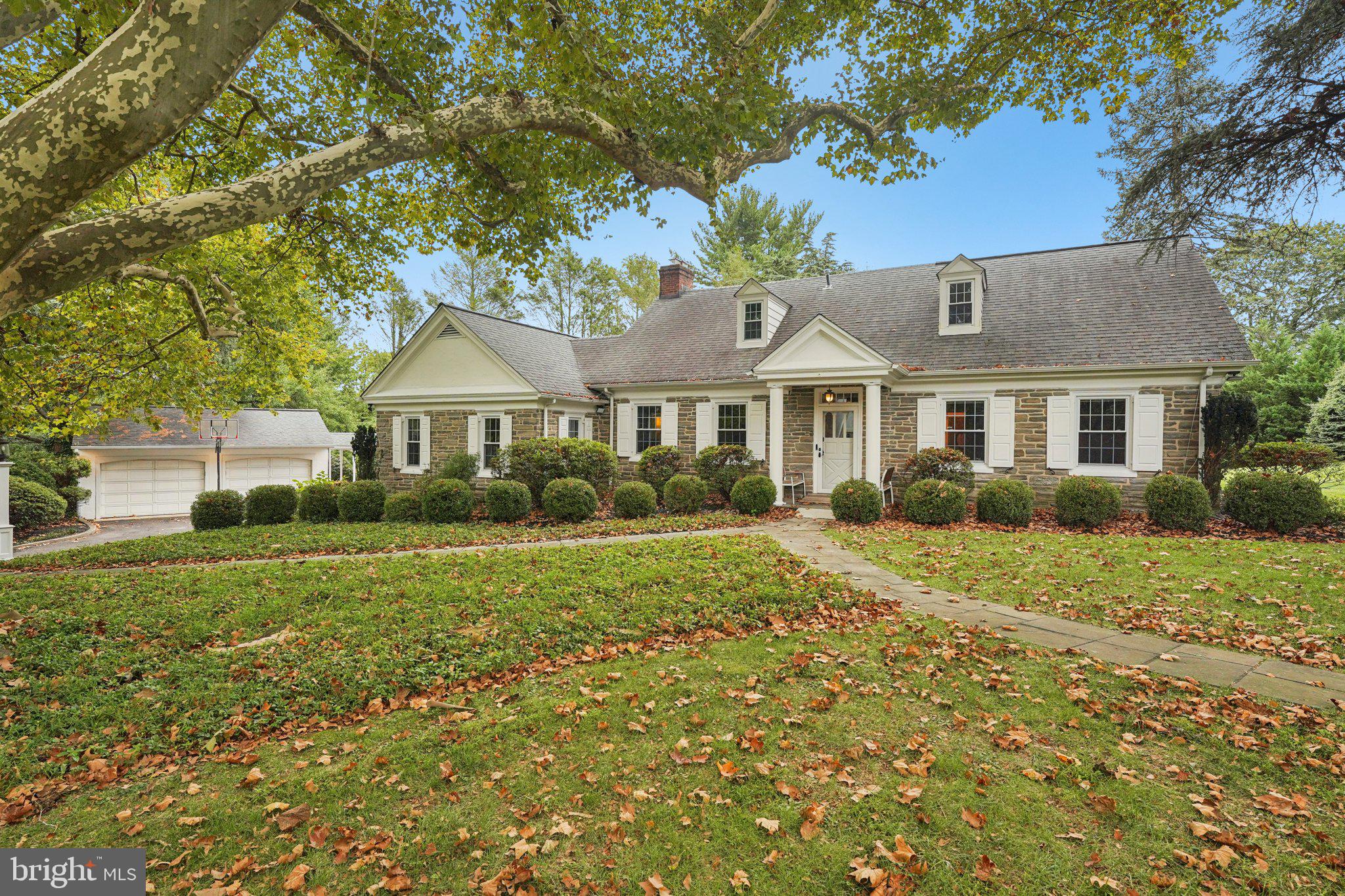 Welcome to 1535 Scrope Road – a distinguished stone Cape Cod in the heart of Rydal. Nestled on a private 1.4-acre corner lot, this home is surrounded by mature trees and stately residences, offering both charm and serenity. A century-old sycamore graces the front yard, a magnificent landmark that sets the tone for this exceptional property. Step into the expansive foyer and immediately feel the quality of craftsmanship—random-width plank floors, high ceilings, custom millwork, and thoughtful built-ins throughout. The home has been sympathetically renovated with careful attention to modern living and full ADA compliance, blending timeless character with accessibility and comfort. The formal living room, with its fireplace and 8+ foot ceilings, introduces the home’s sense of openness and enduring design. From here, move seamlessly to the great room, boasting soaring 10-foot ceilings, a floor-to-ceiling brick fireplace, and a wall of windows overlooking the slate courtyard patio. The dining room and chef’s kitchen create the ideal gathering space. Recently updated, the kitchen features abundant workspace, quartz countertops, a tile backsplash, and top-of-the-line Thermador appliances (WiFi compatible), including an ADA-compliant refrigerator, workstation sink, and ample storage. A private office/library with custom bookshelves and built-in bar provides the perfect work-from-home retreat. Just beyond the kitchen, you’ll find a mudroom, laundry, and an in-law/au pair suite with two rooms and a full bath. On the main level, a beautifully designed bedroom suite connects two spacious bedrooms with a brand-new ADA-compliant bath, complete with heated floors, a zero-entry shower, and a temperature-controlled soaking tub. Upstairs, the Primary Suite offers tremendous space with a huge walk-in closet, two additional closets, built-ins, and a luxurious ensuite bath. A second updated hall bath features a tiled shower with seat, seamless glass doors, and modern vanity. Another large bedroom with walk-in storage completes this lev An extraordinary highlight is the 2,200 sq ft heated indoor pool house—a true entertainment haven with a separate hot tub, wet bar, and full bath. A detached two-car garage with covered access to the mudroom adds convenience.
Meticulously updated by the current owners, this home is a sanctuary—peaceful, private, and filled with character. Located in one of Abington Township’s most desirable and quiet neighborhoods, 1535 Scrope Road is ready to welcome its next chapter.