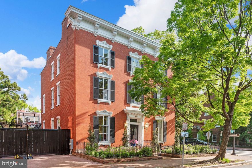 An archetype of Georgetown style, this stunning detached brick Federal exudes grace and sophistication. Sited prominently on one of Georgetown's most historic streets, this extraordinary home offers tremendous scale and grand proportions. Original details, high ceilings and light from a multitude of windows can be found throughout the home. The entry level enjoys light from four exposures and features a double living room, formal dining room, family room, powder room and a generous newly renovated eat-in kitchen with a wall of windows overlooking the expansive patio. The first upper level is home to a spacious primary bedroom with en-suite bathroom, a hall bath and two additional bedrooms that provide great flexibility as potential office or workout spaces. The top level has a hall bathroom and four very well proportioned bedrooms that enjoy abundant light. The lower level has a large family room, full bathroom and designated office space. Two car parking tops off the long list of amenities in this wonderful and significant home.