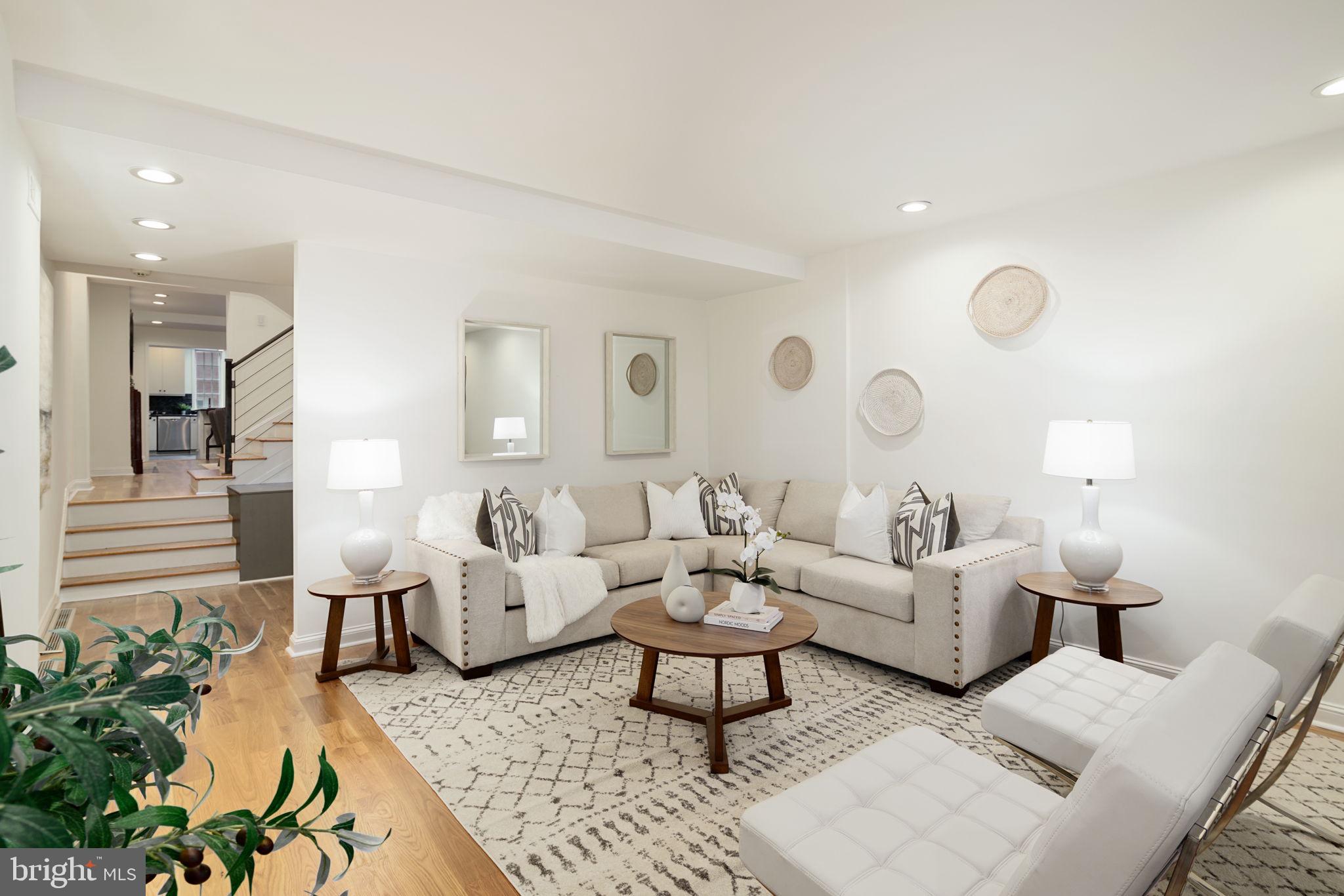 2028 Locust Street is newly updated, freshly painted and meticulously maintained! A one-of-a-kind 4 bed, 4.5 bath home bathed in sunlight from 3 exposures! This premium location is just steps from the world-renowned Rittenhouse Square, long regarded as the most desirable neighborhood in Center City. Enter the grand living room spacious enough for two sitting areas, with brand new, finished in-house 5½ inch-wide white oak hardwood floors throughout, built-in speakers, and just-installed LED recessed lighting that flows into the large dining space, perfect for entertaining around a stunning marble fireplace. Continue on to the fully equipped chef’s kitchen, swimming in natural light from multiple windows, featuring an open breakfast bar, ample storage space, elegant newly-tiled backsplash, white cabinetry, and stainless steel appliances including a 36” Viking 6-burner stove, Bosch dishwasher, Liebherr refrigerator/freezer, drawer microwave and customizable wine fridge. To complete this level, find additional closet space and an elegant half bathroom. Take the eye-catching center staircase to the second floor boasting a generous primary suite bedroom with a wall of custom closet space, more recessed lighting and an ensuite bathroom with a dual vanity, luxury Toto toilet, tiled floors and dual-head shower, frameless glass door, and whirlpool spa tub. Also on this floor find a South-facing den/family room/office with leaded glass windows, a fireplace and sliding glass doors to the private and serene deck surrounded by new planters with an automated watering system. Travel to the third level with natural light flooding through the large domed skylight and original 10 over 10 true divided light window, and find 2 more spacious, bright and open bedrooms and a shared full bathroom with pedestal sink and tub/shower. Go up one more flight of stairs to the lofted bedroom overlooking Locust Street, with ample closet space and an ensuite bathroom with tiled shower and vanity with storage. The lower level features natural light from full-sized, Southern-exposure windows, a carpeted flex space, playroom and mudroom area with separate access outdoor storage alcove, plus a front game room/lounge/exercise room and discrete laundry area. Also find a newly updated full bathroom with high-end Kohler fixtures and raindrop shower head. Deeded parking easily accessible through kitchen and basement entrances, with heated outdoor steps so no need to salt/shovel on those icy winter days! Dual zone HVAC. This home is a rare combination of size, style, and desirable location in the Greenfield catchment, steps from Rittenhouse Square, shopping, dining, and all that Center City has to offer!