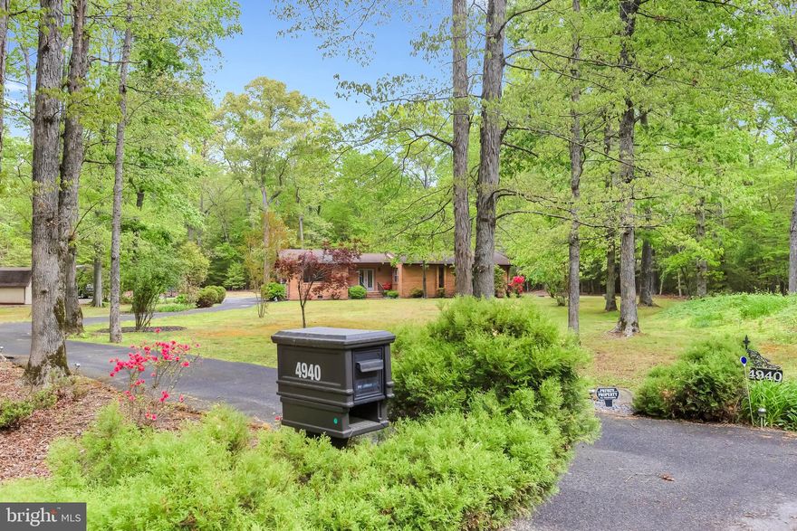 Tucked away in a serene, park-like setting, this beautifully maintained home offers the perfect blend of privacy, comfort, and thoughtful updates. Surrounded by mature trees and set on a spacious lot, the property welcomes you with a circular driveway and a peaceful, nature-filled approach.

Inside, you’ll find fresh paint and updated LVP flooring that create a bright, modern feel throughout the home. The layout offers generously sized rooms with large closets, providing ample storage and everyday functionality. The home has been well cared for with major system updates already completed, including two newer water heaters, updated bathrooms with clean, modern finishes, a dedicated laundry/mudroom with 1/2 bath and exterior access, roof approximately 8 years old, a 3-year-old HVAC system, and septic replaced in 2016 giving buyers added peace of mind.

The heart of the home is the open dining area and kitchen, where you’ll find ample cabinet space, stainless steel appliances, and a large breakfast bar—perfect for casual dining or gathering with friends and family. The dining space is surrounded by windows, bringing the outdoors in and creating a warm, inviting atmosphere.

Cozy up by the woodstove, perfect for adding warmth and charm during cooler months. The home also features a versatile outdoor space with a spacious deck and enclosed porch—ideal for relaxing, entertaining, or simply enjoying the tranquil surroundings.

Additional highlights include multiple outbuildings for storage, hobbies, or workspace, and the benefit of an inactive HOA, offering flexibility without restrictions.

If you’ve been searching for a private retreat with modern updates and room to breathe, this property delivers a rare opportunity to enjoy quiet living while still being conveniently located.