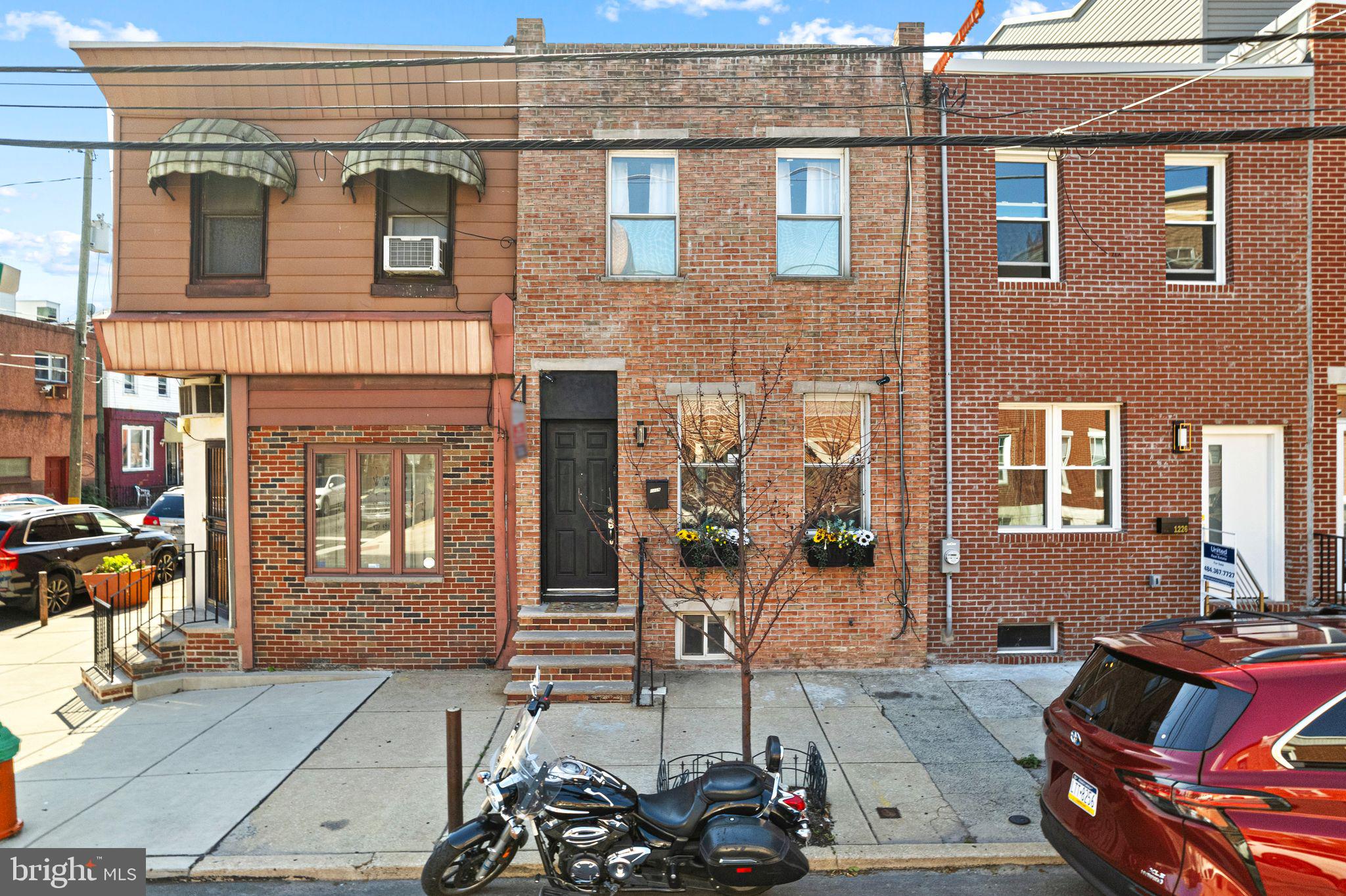 MOTIVATED SELLER, BRING YOUR OFFERS!
Welcome to this charming and beautifully refreshed Philadelphia row home that's filled with light and character. Enter the front door into the open concept living room with wood flooring, hi hat lighting, ceiling fans, and over-sized windows. The living room leads seamlessly down a hallway past a convenient half bath and into the dining room area with a ceiling fan and hi hat lights of it's own.. Through a doorway from the dining room leads to an updated kitchen with bright white cabinetry, stainless steel appliances, and a bright open sliding glass door directly to the private back patio space, perfect for hosting a BBQ or relaxing with family outside. Upstairs you'll find three cozy bedrooms and an updated full hall bathroom. The rear bedroom boasts access to a beautifully refinished deck overlooking the patio and the front master bathroom offers a full en suite bathroom. For even more space, the finished basement offers a mix of cemented space for storage, a dedicated laundry area, and a finished carpeted room perfect for home office, a bonus playroom. Located in the heart of Point Breeze within walking distance to several parks, grocery stores, coffee shops, breweries, and restaurants, this home offers unmatched comfort and convenience. Schedule your tour today!